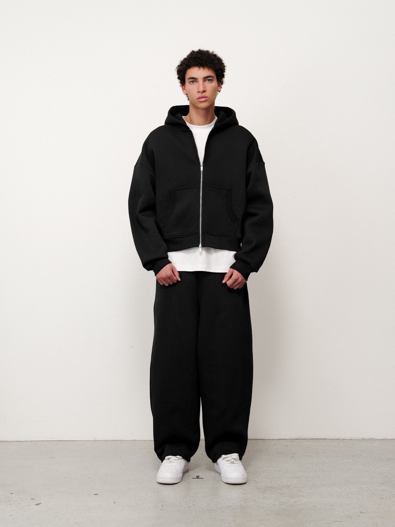 Black Cozy Zip Up hoodie by Sweats EU, featuring a front zipper, comfortable fit, and casual style, shown on a model.