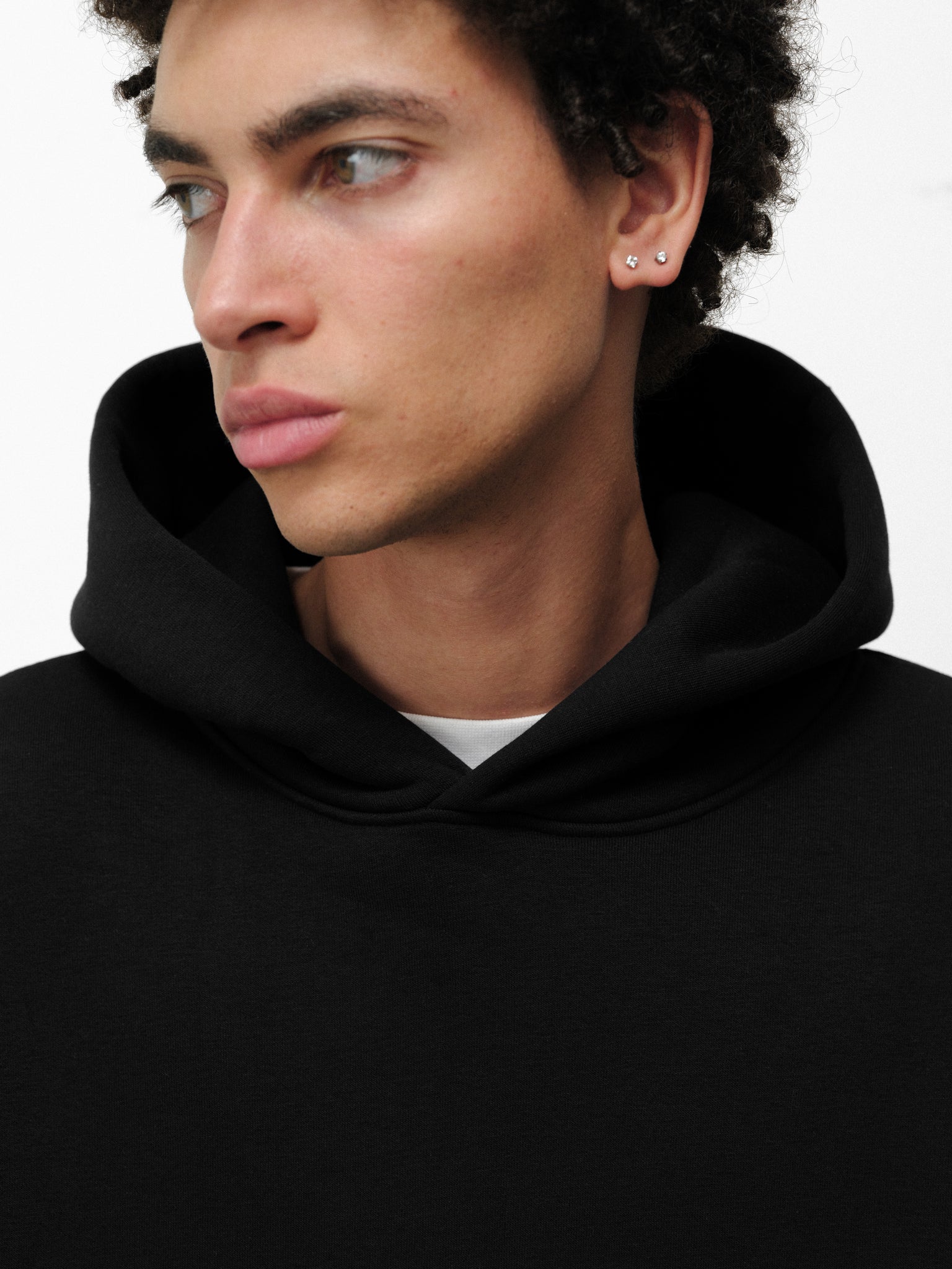Black Cozy Hoodie from Sweats EU with a front pocket and drawstring hood, displayed on a neutral background.