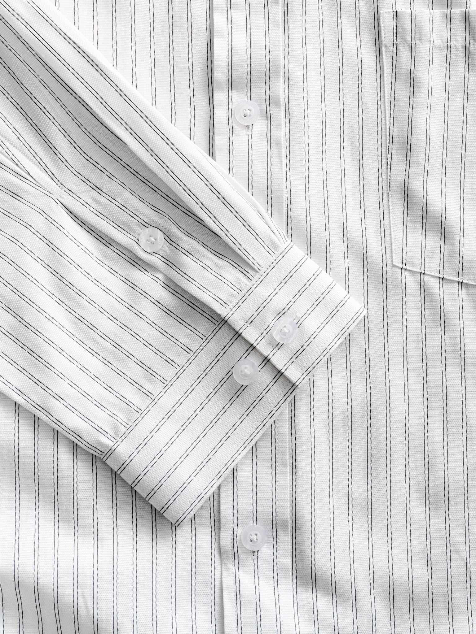 White striped button-up shirt from SWEATS EU, neatly folded with visible collar and button details.