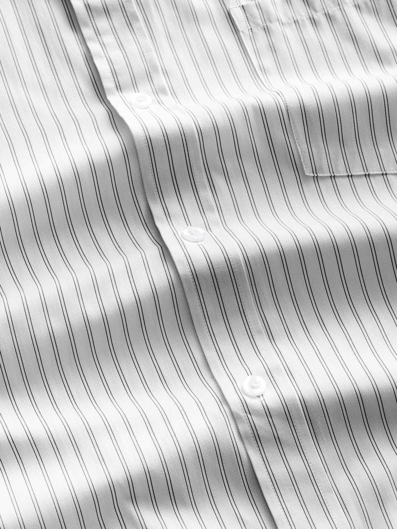 White striped button-up shirt by SWEATS EU laid flat, showing the classic collar, button details, and crisp fabric.