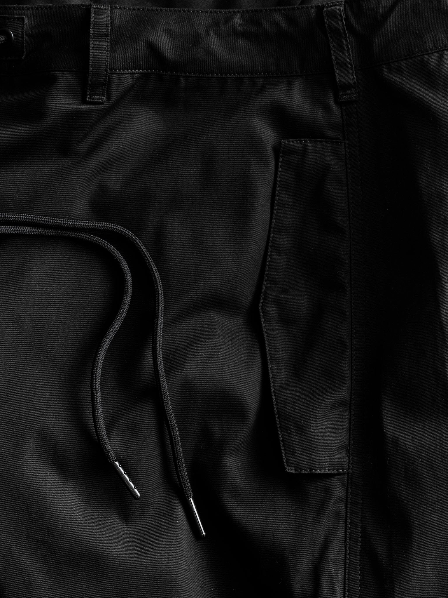 Black V3 Flight Shorts by SWEATS EU displayed flat with waistband, highlighting their design and fabric texture.