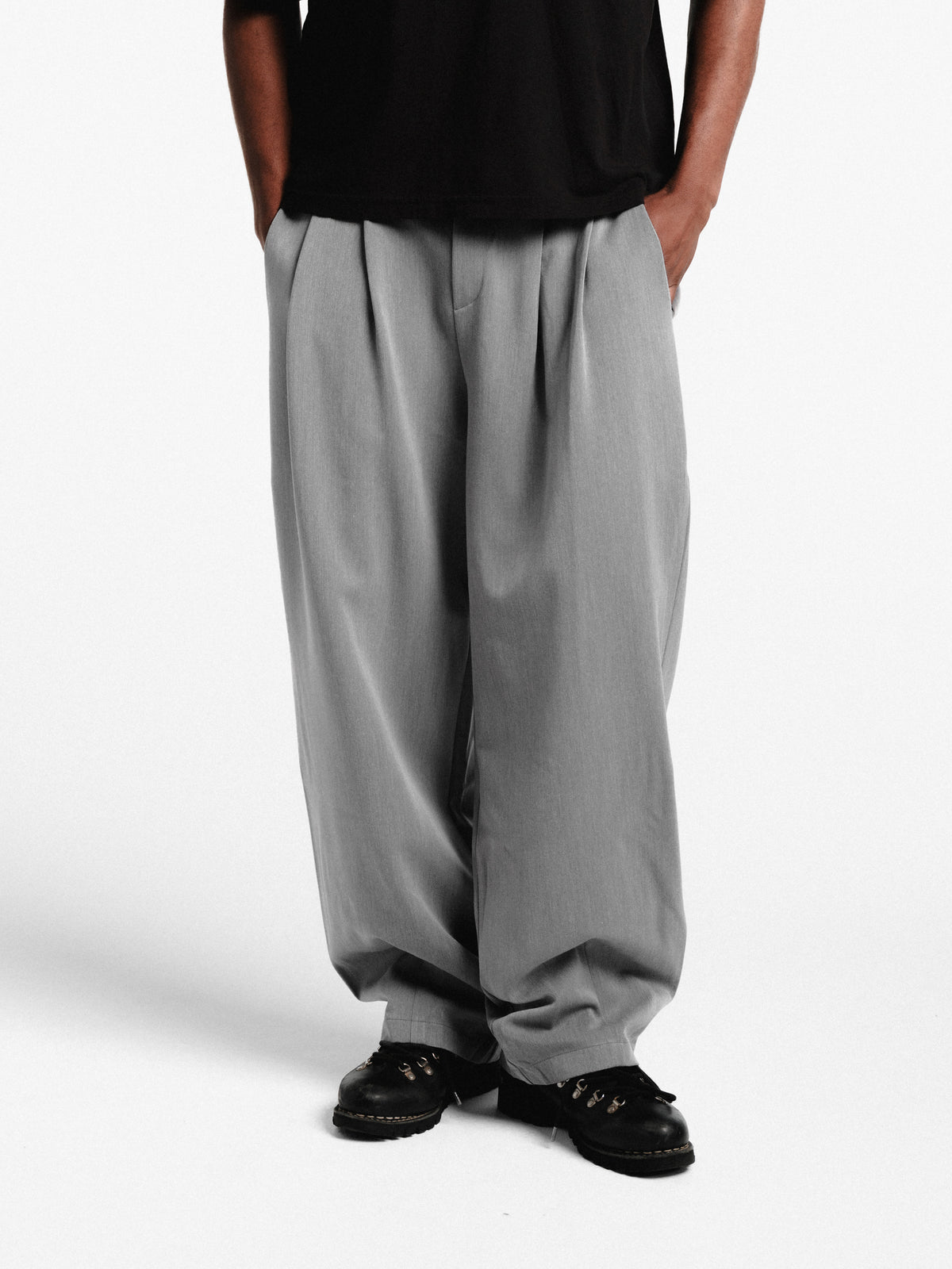 Grey pleated pants by Sweats EU, featuring a tailored fit and classic design, displayed on a neutral background.