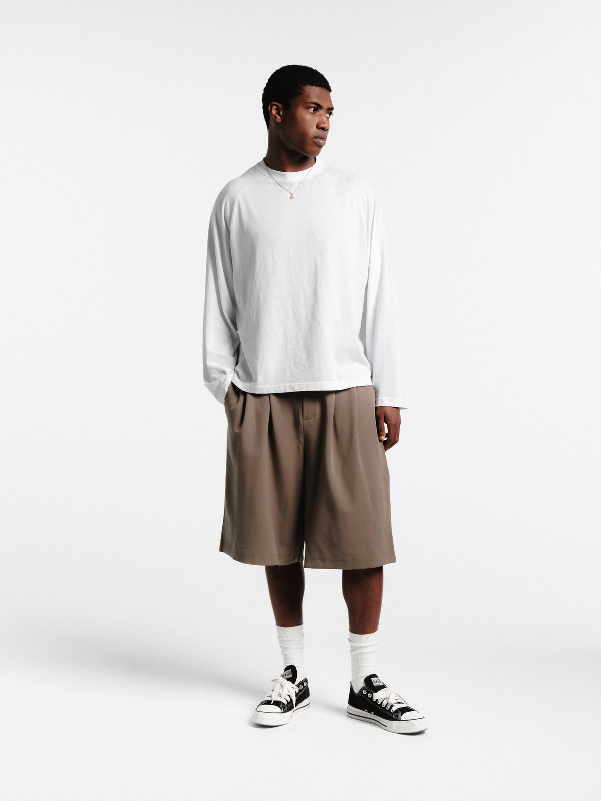 Brown pleated shorts by Sweats EU, featuring a stylish design and comfortable fit, shown on a model in this image.