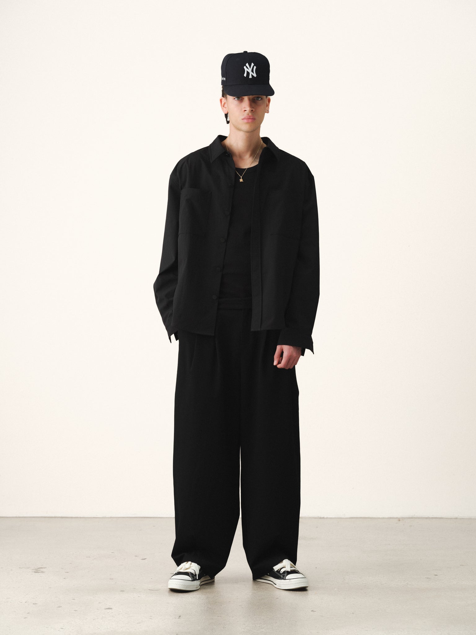 Black Signature Button Up shirt by SWEATS EU displayed on a hanger, showcasing its classic collar and tailored fit.