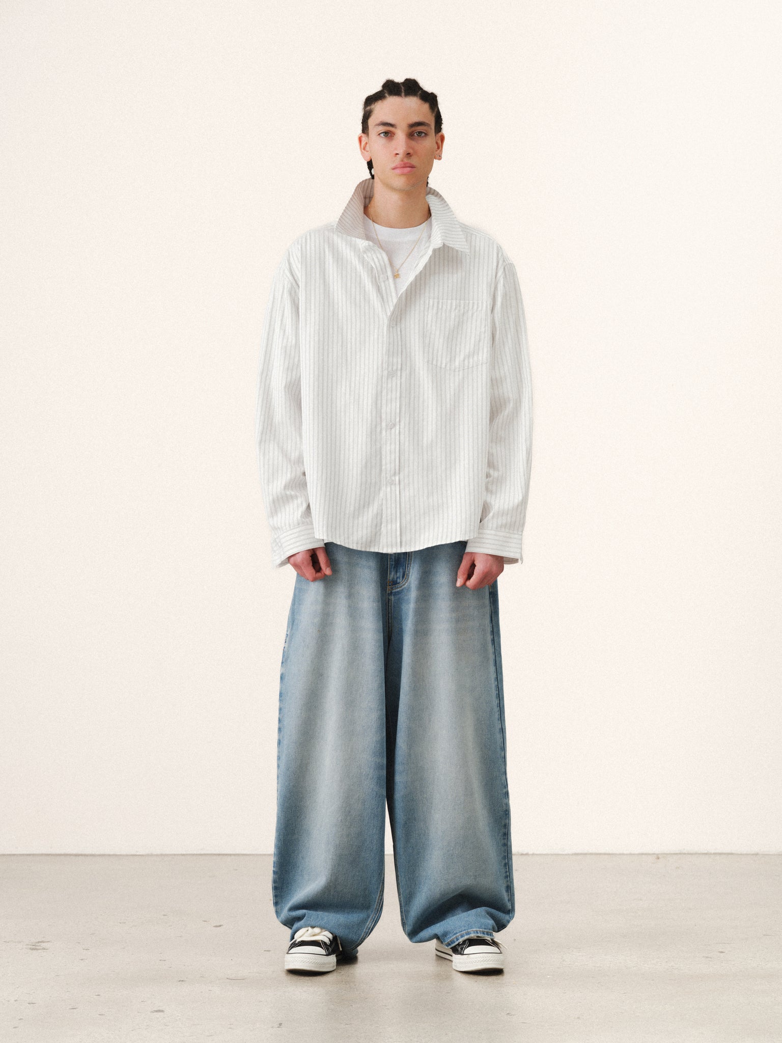 White striped button-up shirt by SWEATS EU, displayed on a hanger with a focus on the collar and button details.