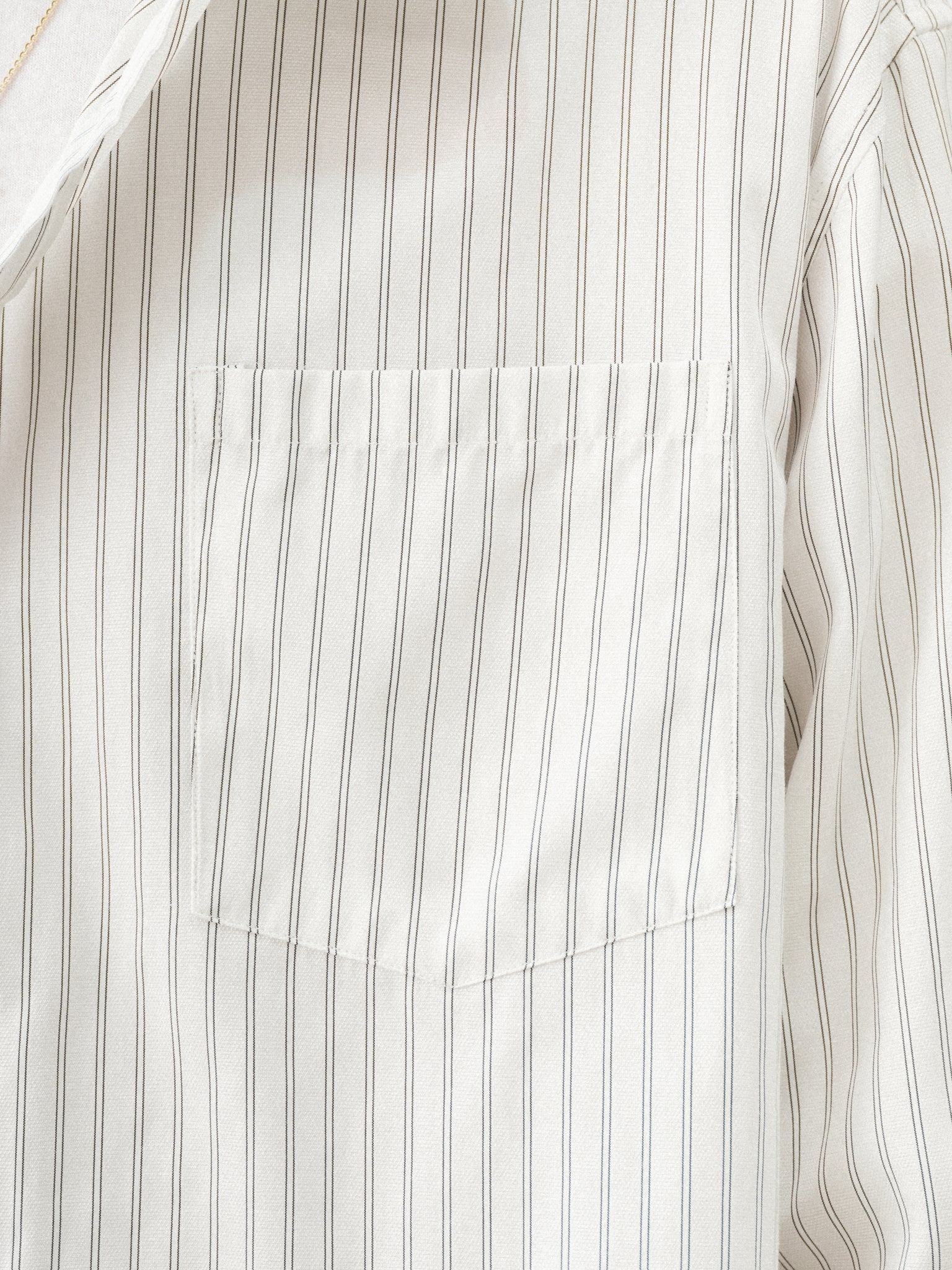 White striped button-up shirt by SWEATS EU, shown laid flat with collar and button details for summer casual style.