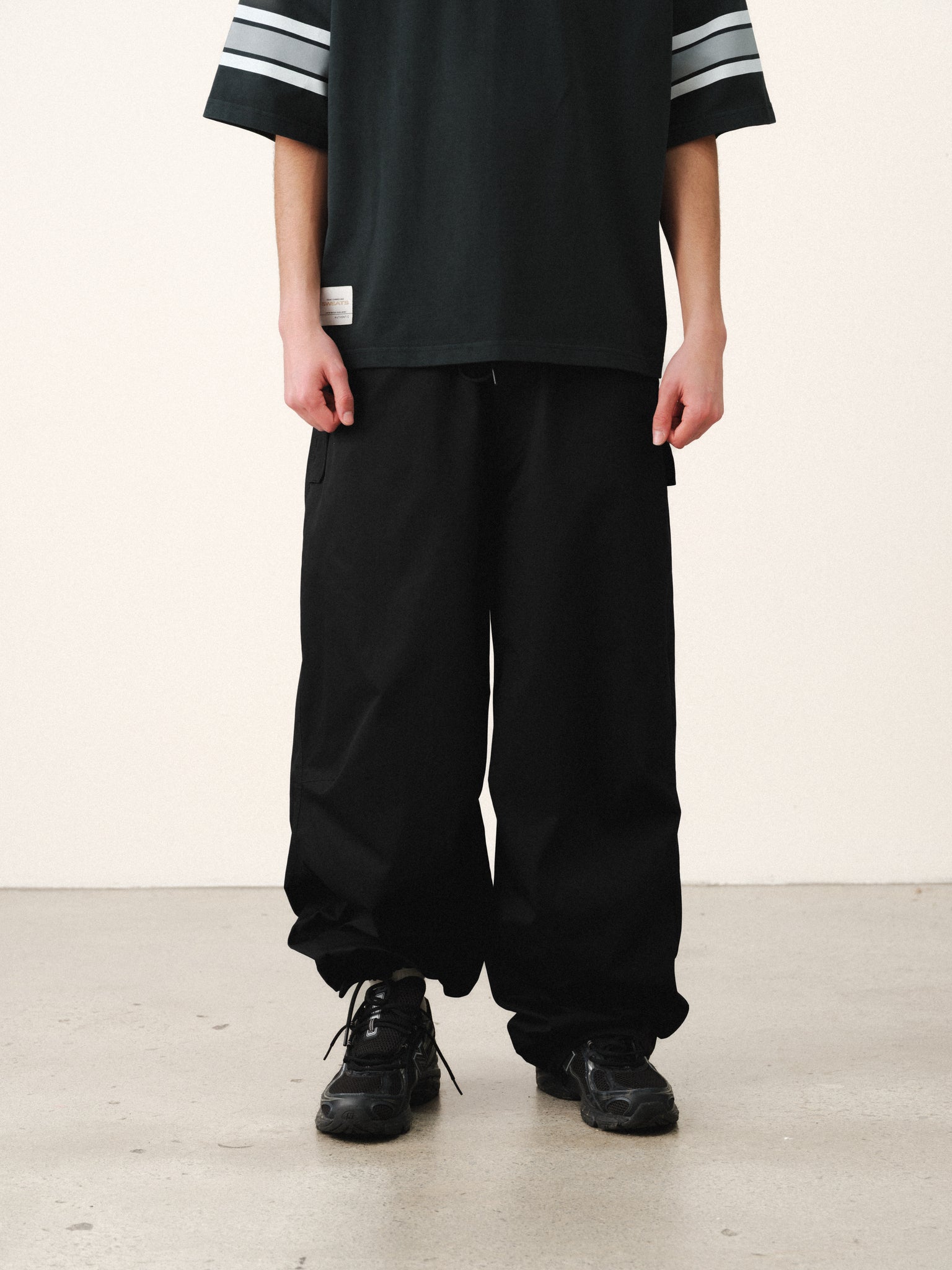 Black V3 Flight Pant from SWEATS EU, featuring a relaxed fit and stylish design, shown on a model with casual summer wear.