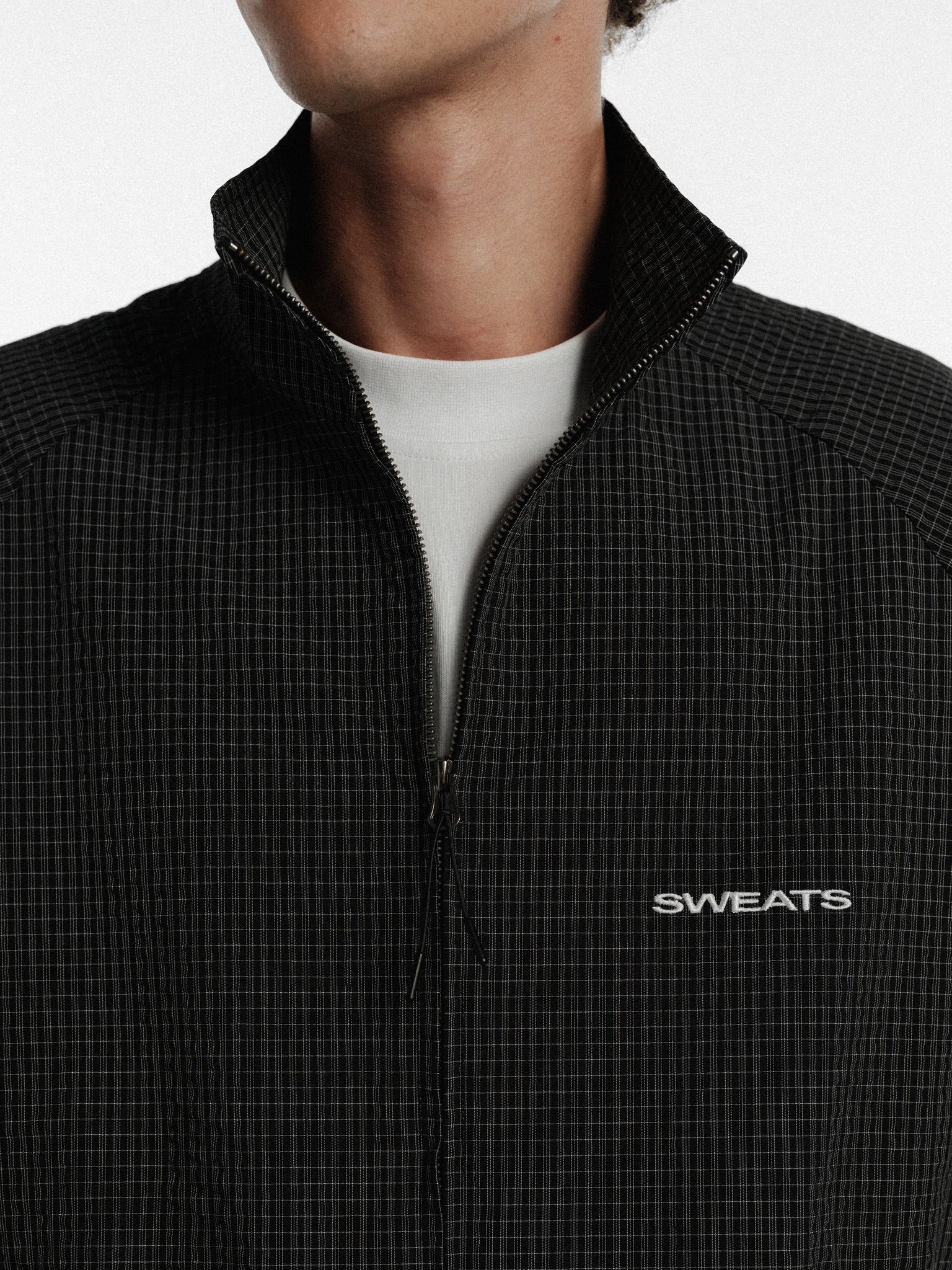Black and white checked track jacket from Sweats EU, featuring a classic sportswear design and comfortable fit.
