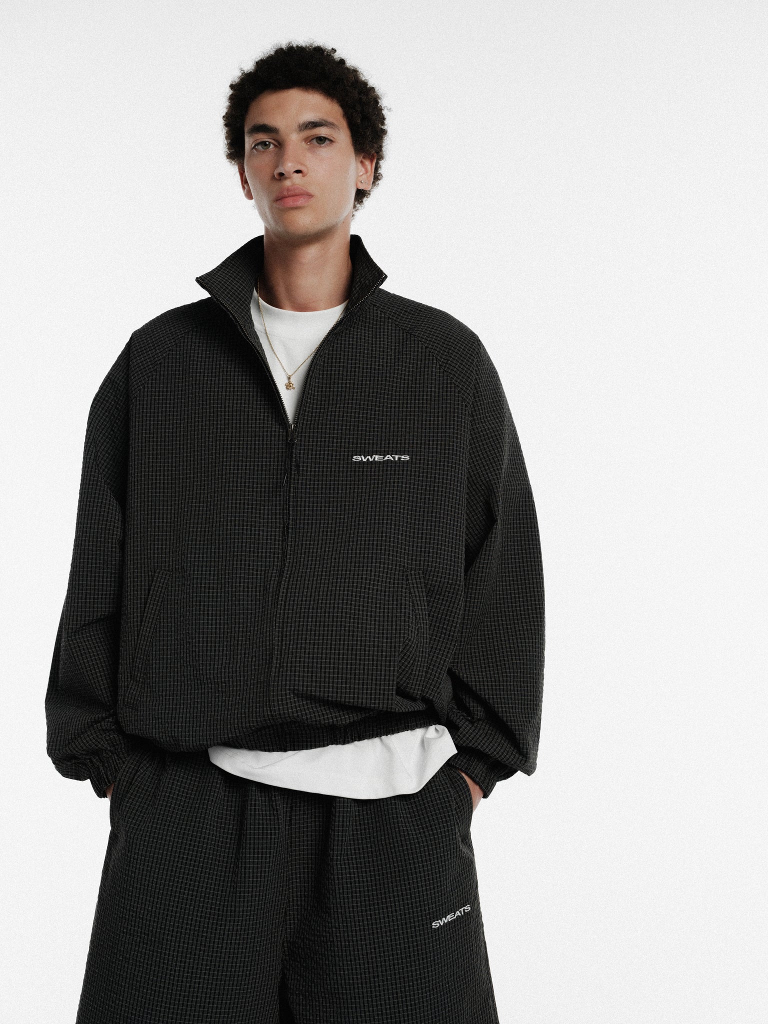 Black and white checkered track jacket from Sweats EU, featuring a stylish sporty design and comfortable fit.
