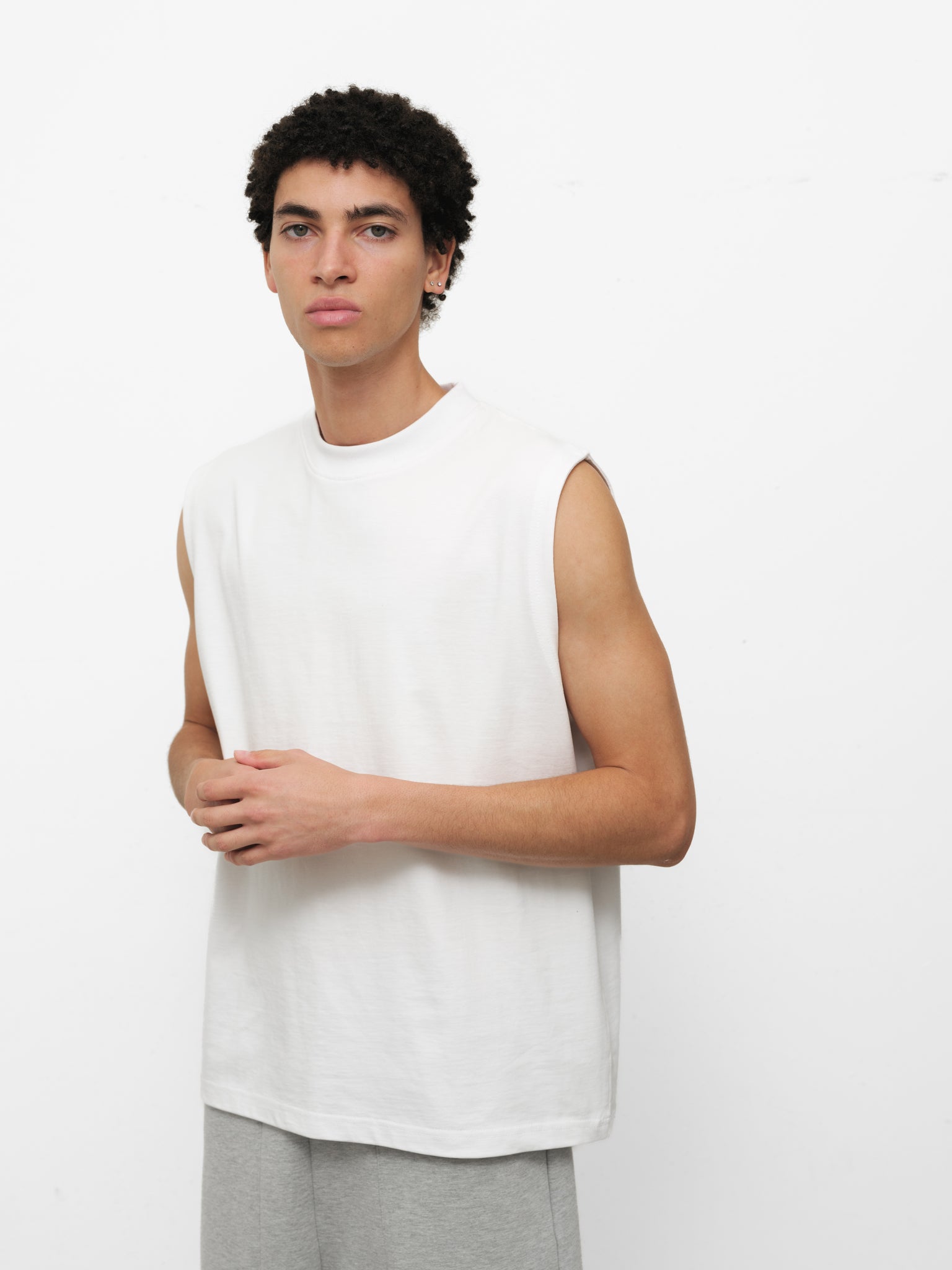 White muscle tee by SWEATS EU featuring a sleeveless design and casual fit, shown on a plain background.