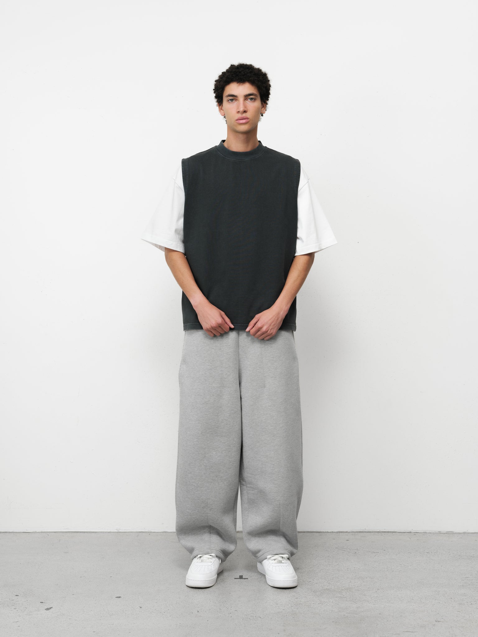 Washed black muscle tee by SWEATS EU displayed on a hanger, showcasing a casual sleeveless shirt with a relaxed fit.