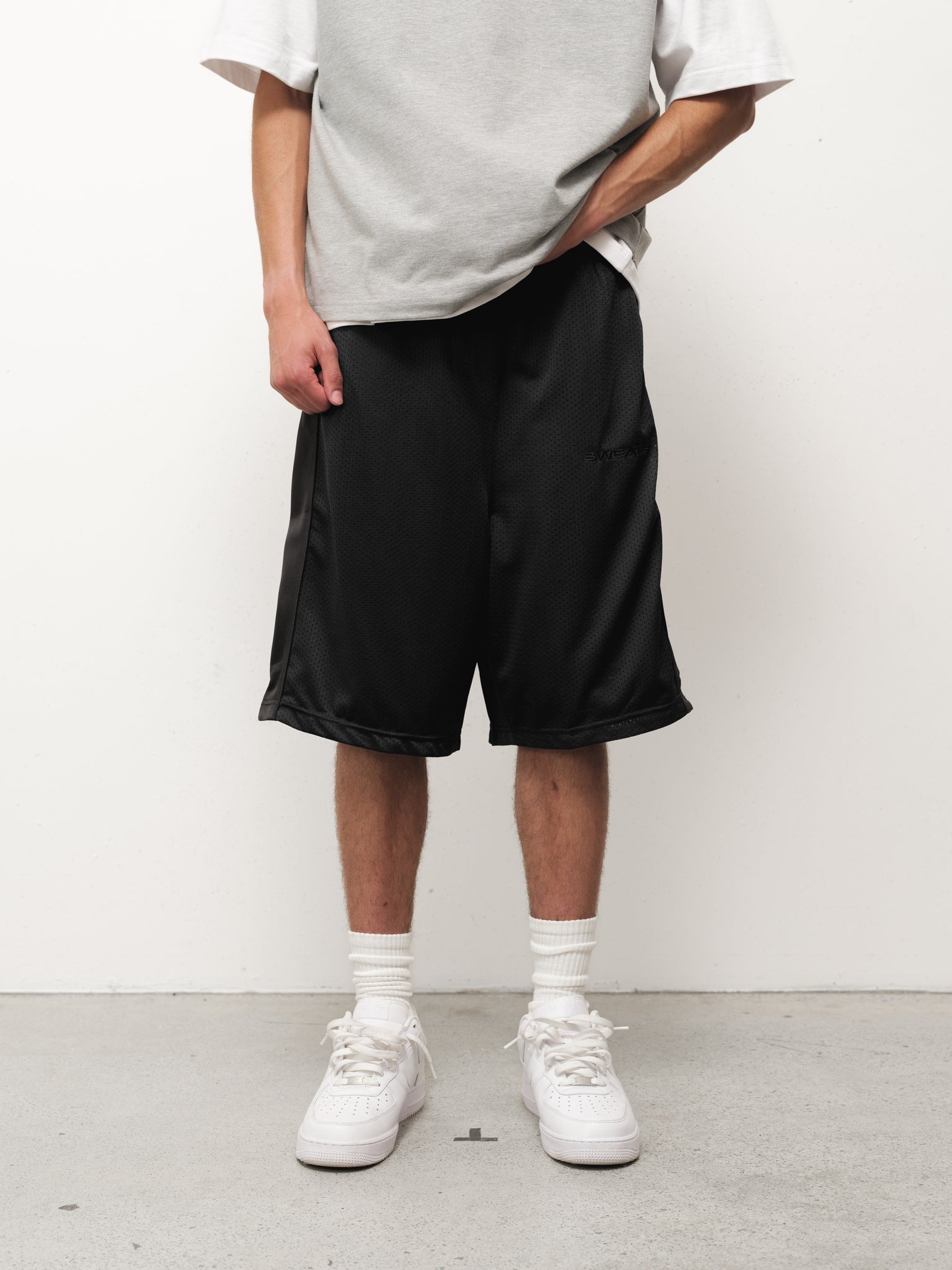 Black mesh shorts from Sweats EU displayed in a full stock image showcasing their lightweight and breathable design.