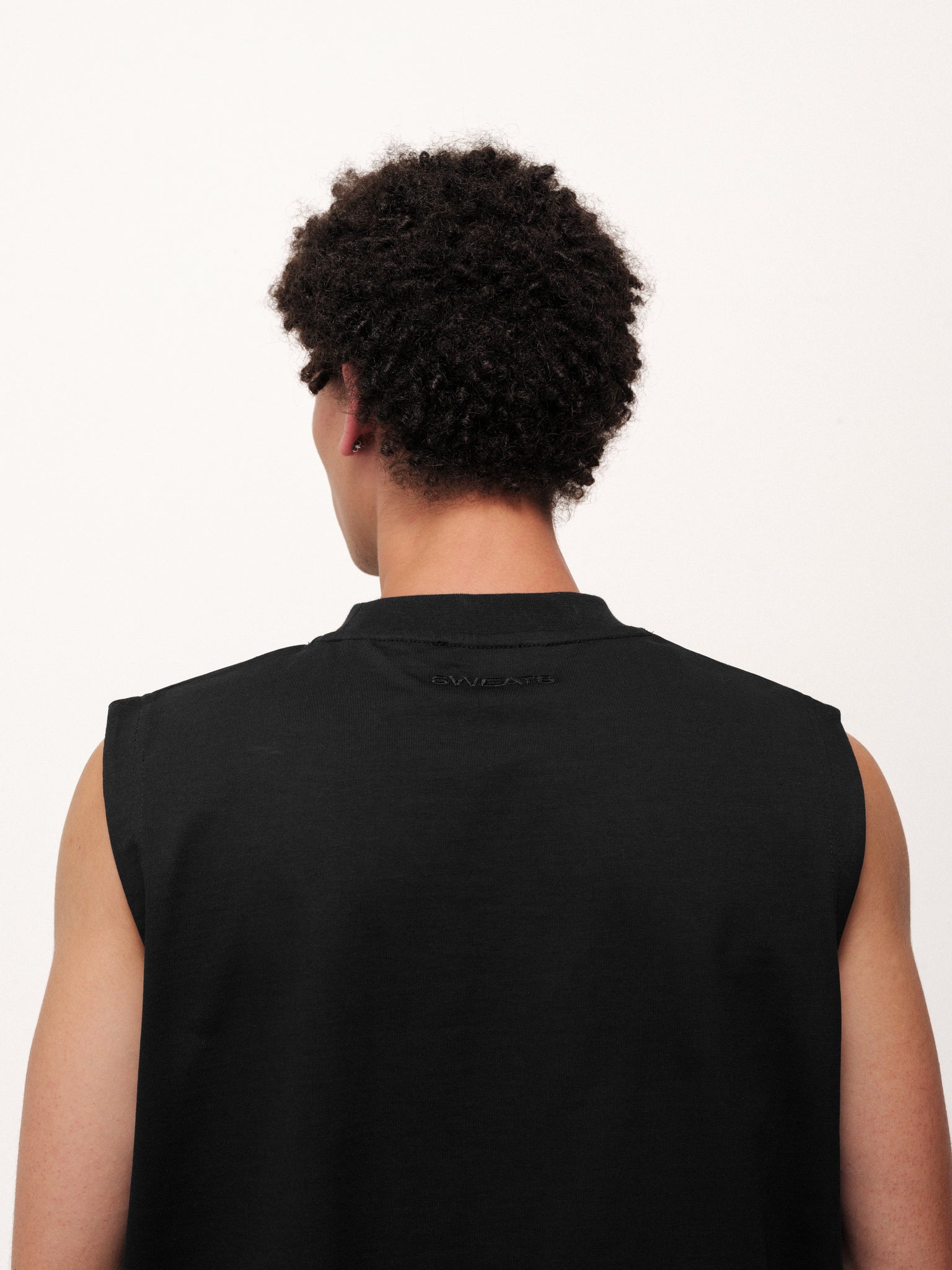 Black muscle tee from SWEATS EU featuring a fitted sleeveless design and casual athletic style.