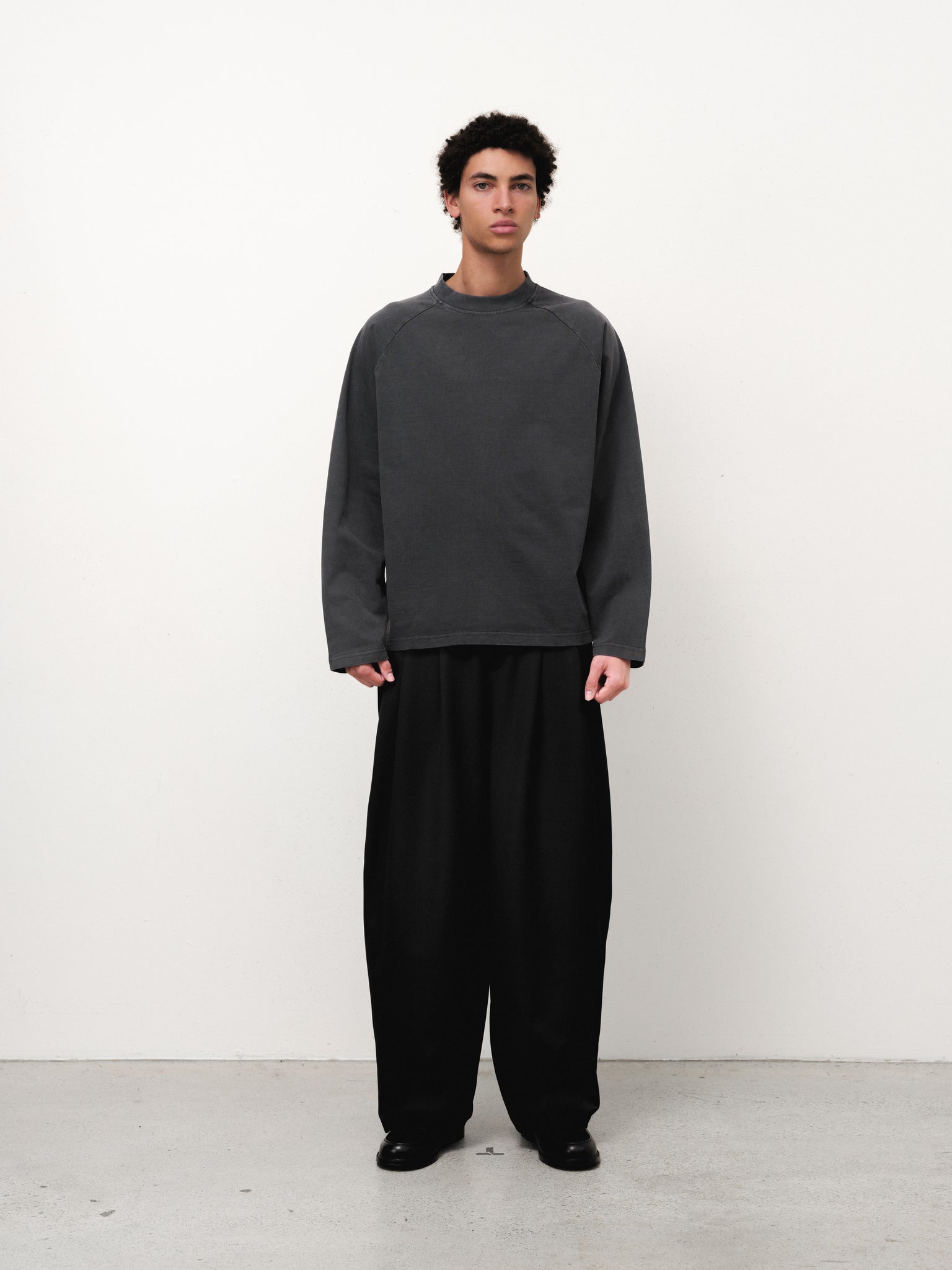 Washed black long sleeve T-shirt from Sweats EU displayed on a model in a full stock photo.