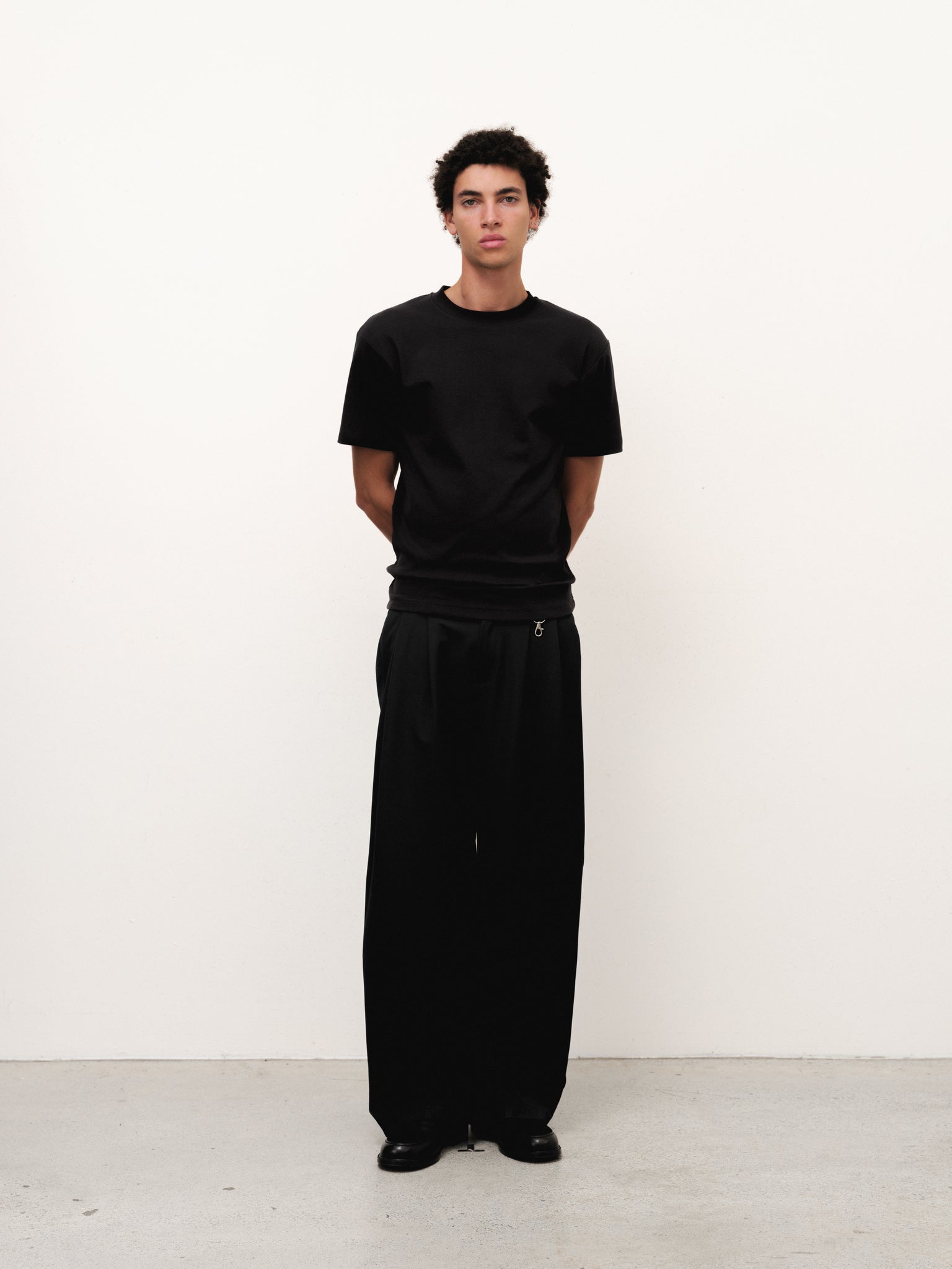 Black fitted T-shirt by SWEATS EU displayed on a mannequin, showcasing a sleek, tailored fit and soft fabric texture.