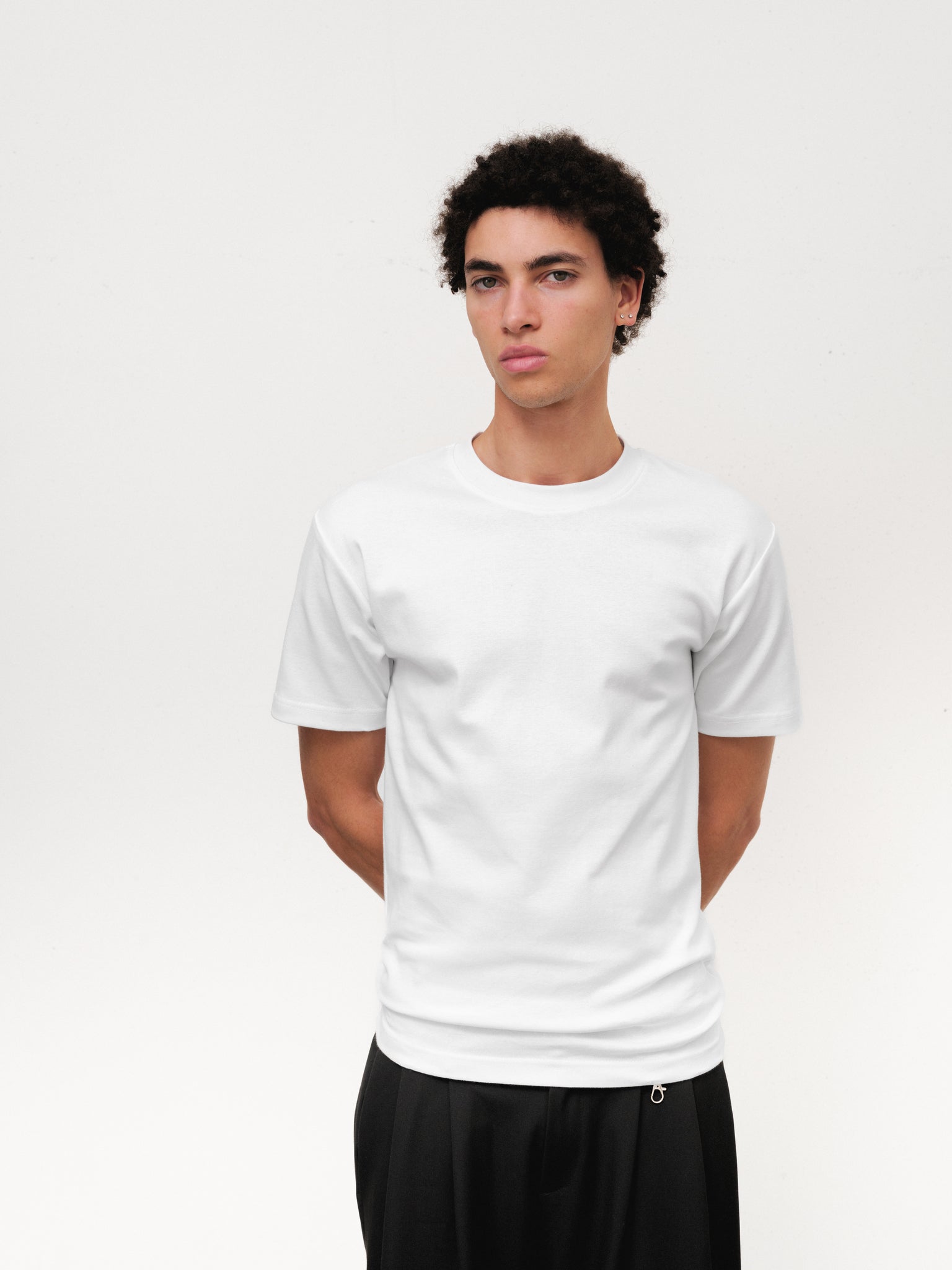 White fitted T-shirt from SWEATS EU, displayed flat with a close-up of the fabric and neckline for a clear product view.