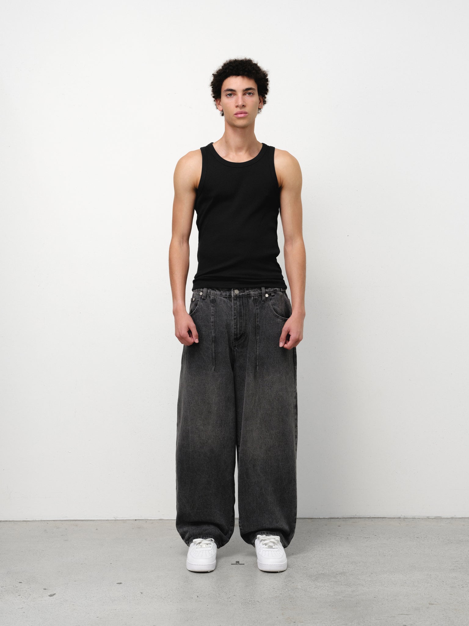 Black tank singlet by Sweats EU, plain sleeveless top shown flat on a white background.