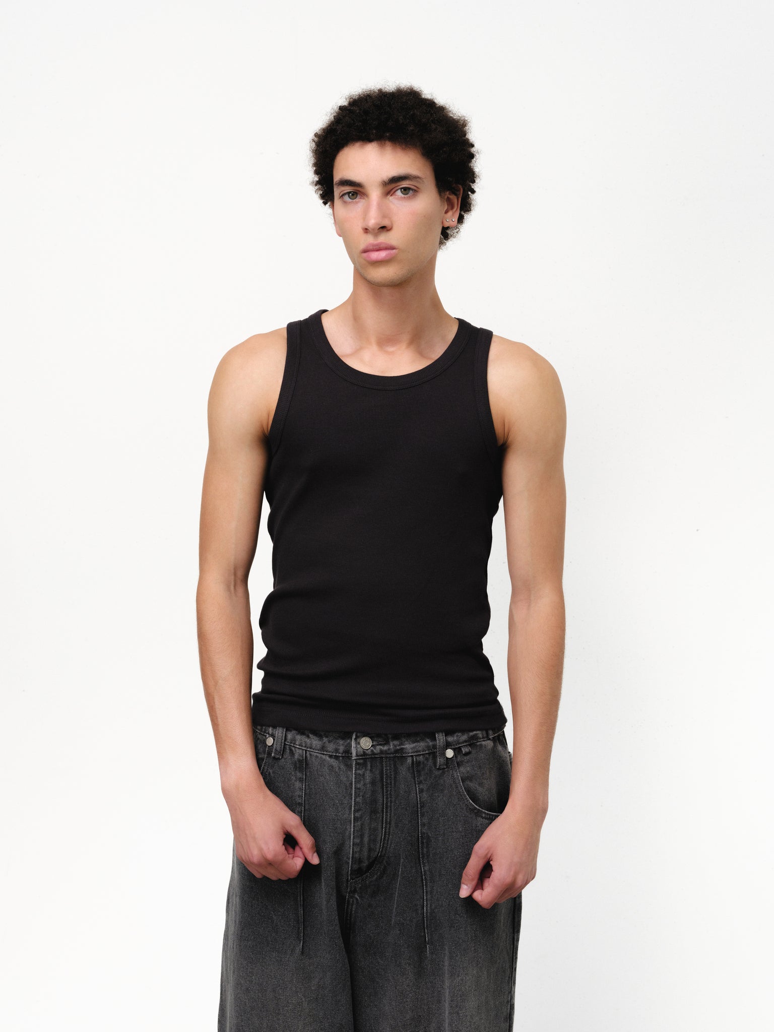 Black tank singlet from Sweats EU, sleeveless athletic top, laid flat showing shoulder straps and simple design.