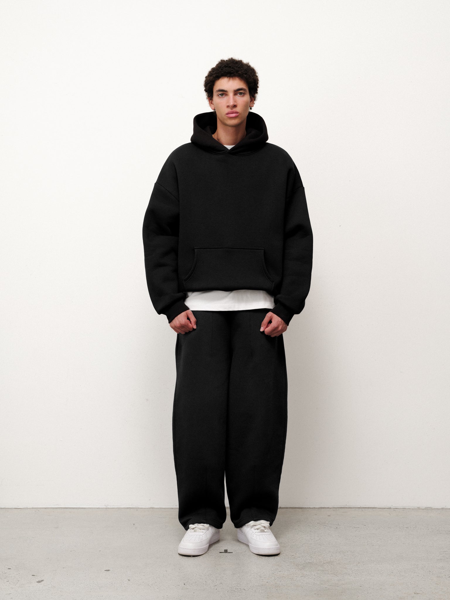 Black Cozy Hoodie by Sweats EU, featuring a comfortable fit with a hood and soft fabric, shown on a model.