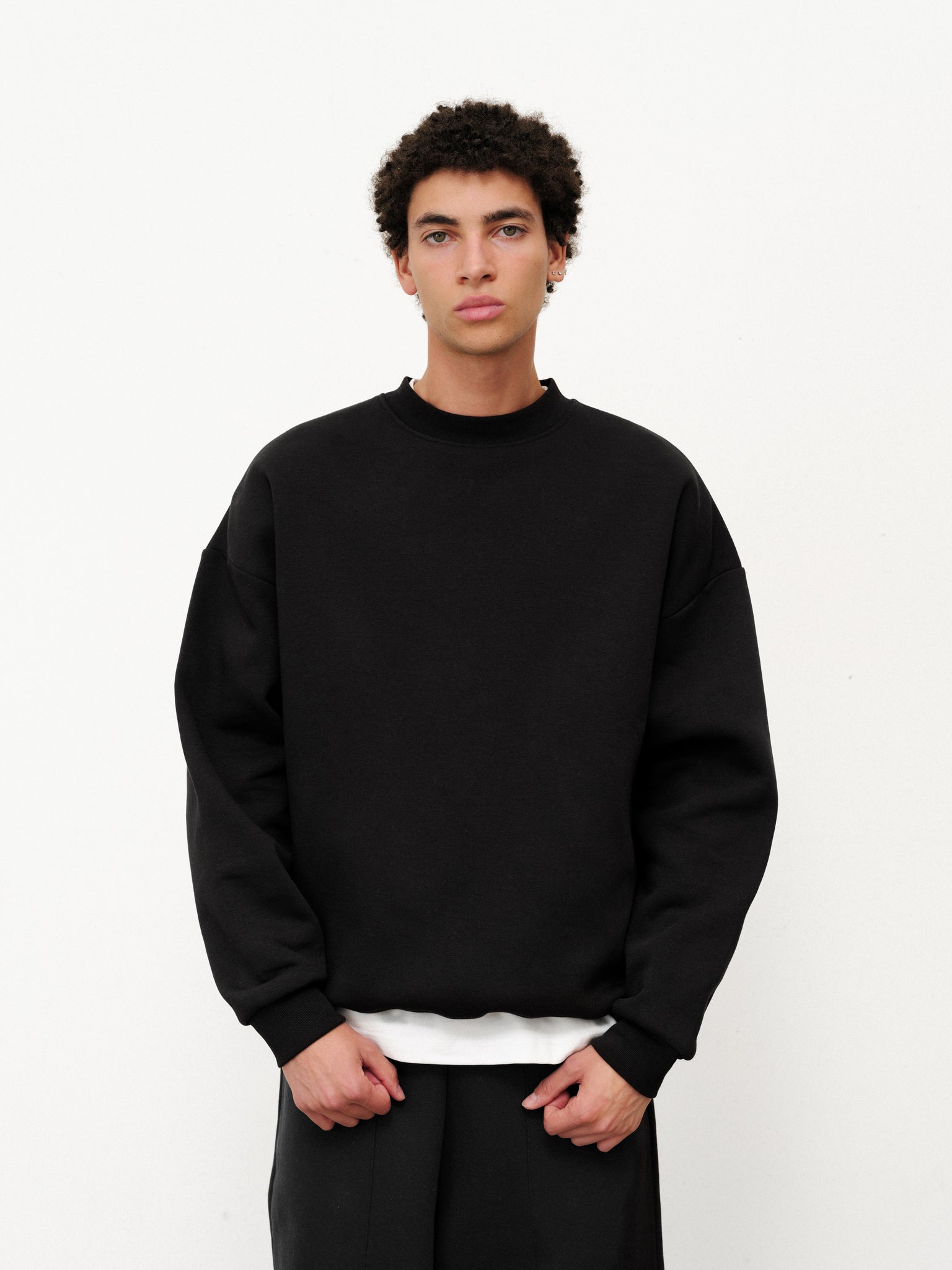 Black cozy Sweats EU sweater with a soft knit texture, long sleeves, and a relaxed fit.