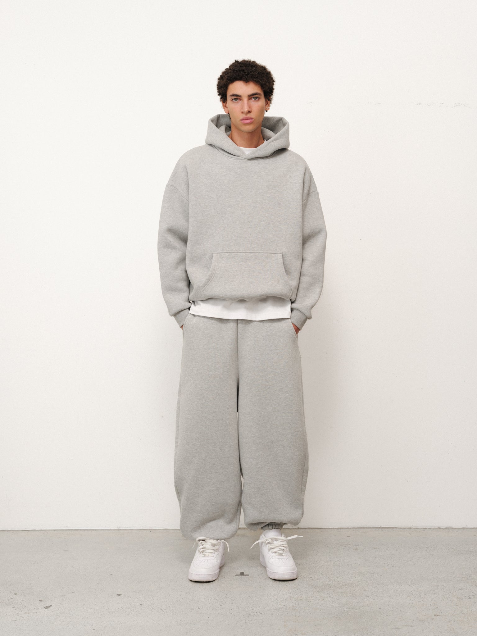 Gray cozy hoodie from Sweats EU with a relaxed fit, soft fabric, and adjustable drawstrings, shown laid flat.