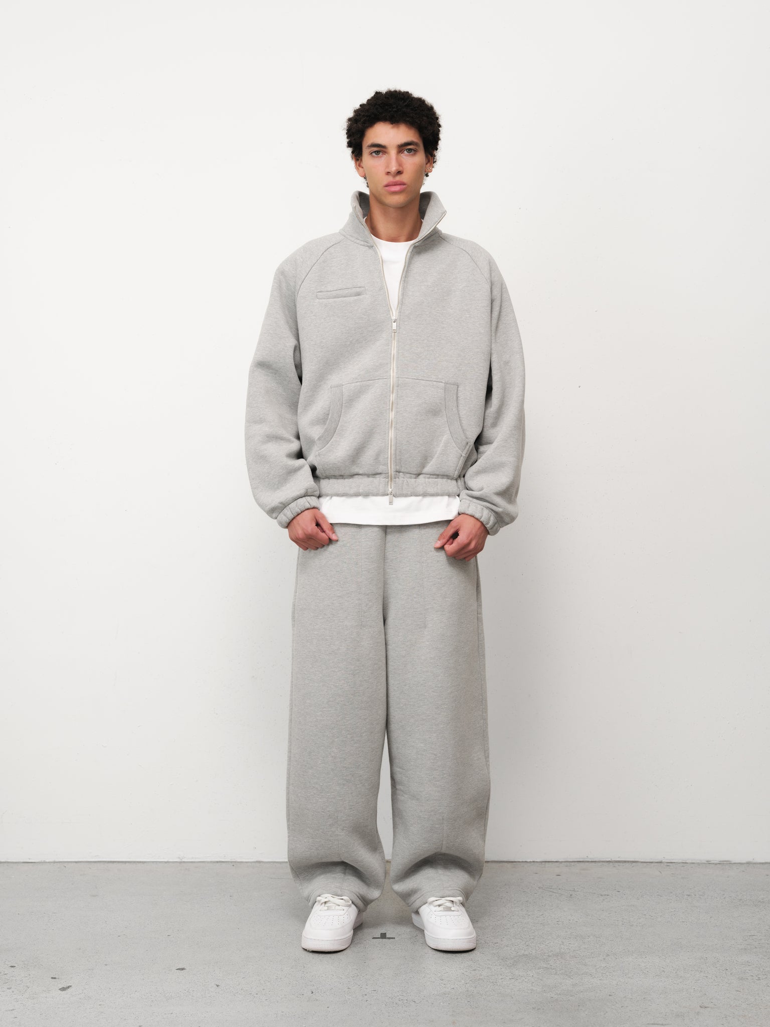 Grey Cozy Track Jacket by Sweats EU laid flat, showing front view with zip closure and ribbed cuffs and hem.