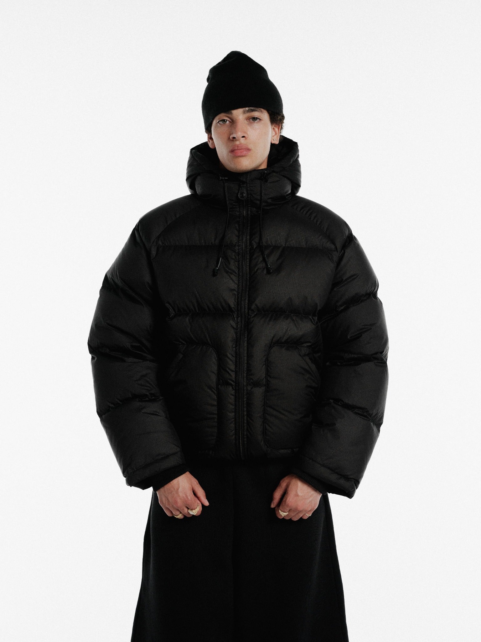 Black hooded puffer jacket by SWEATS EU, showing a front view with a quilted design and adjustable hood.