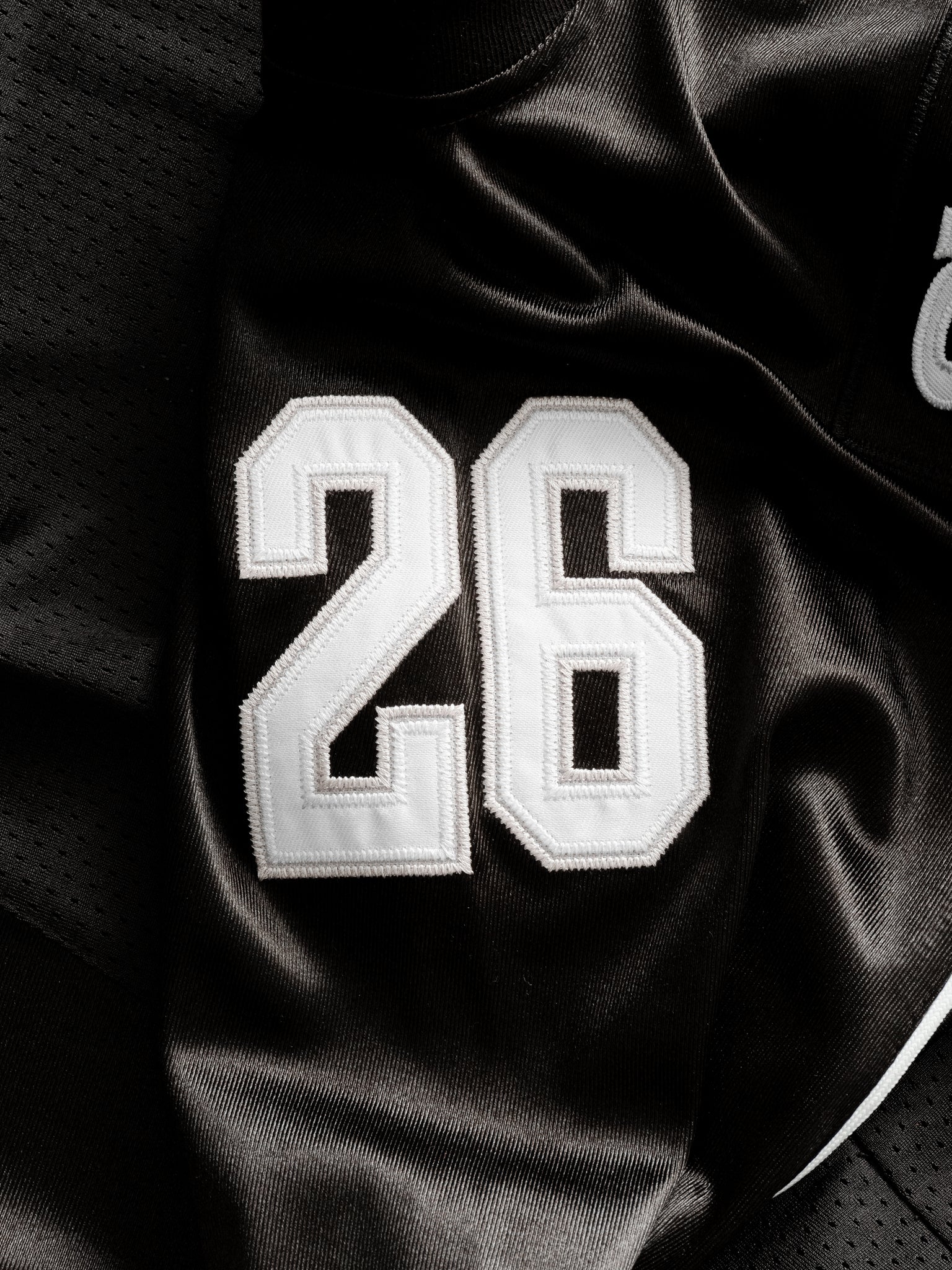 Black Signature Jersey by SWEATS EU displayed flat, showcasing its sleek design and fabric texture.
