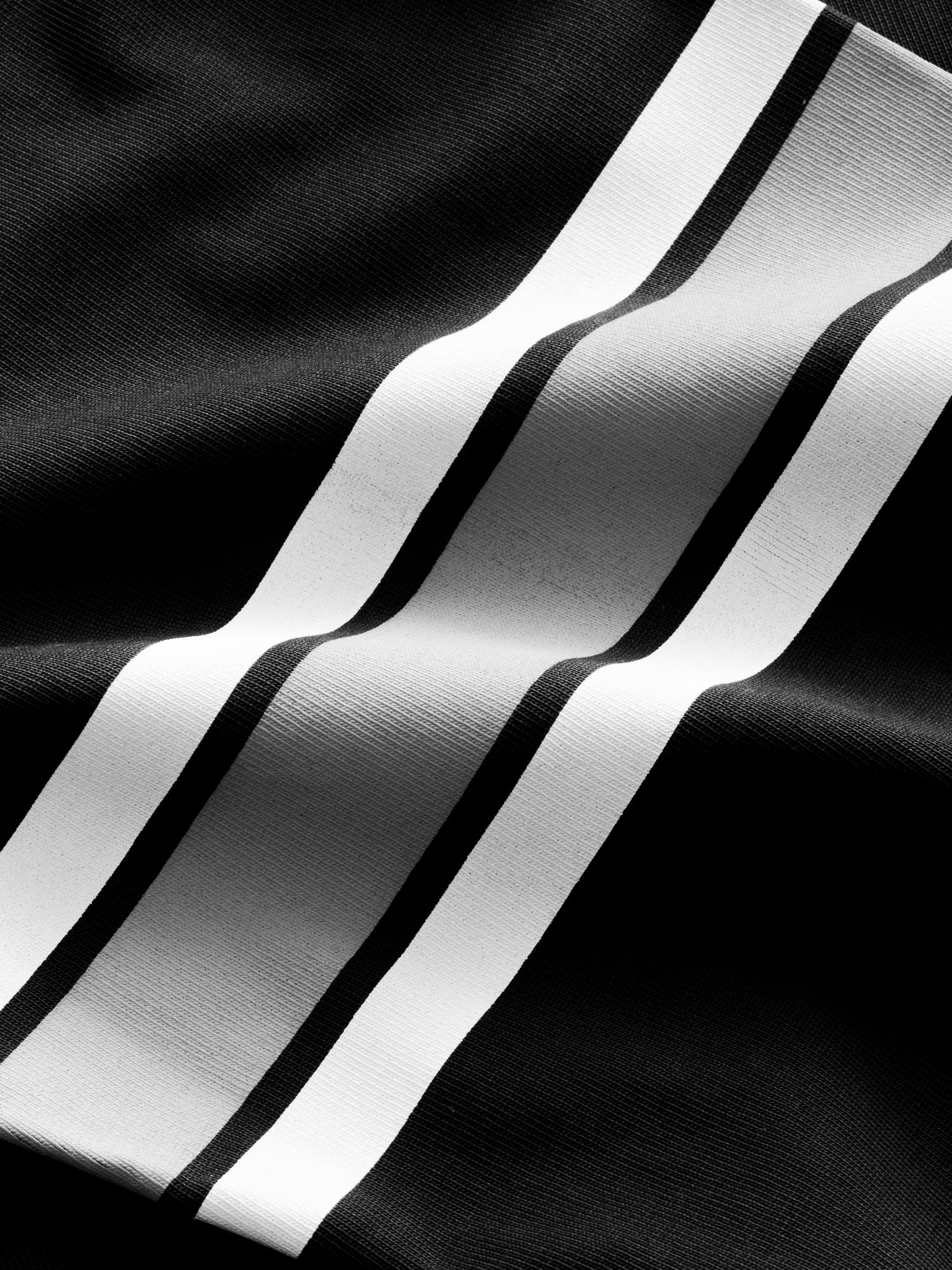 Washed black long-sleeve jersey T-shirt from SWEATS EU displayed flat with visible crew neckline and soft fabric texture.