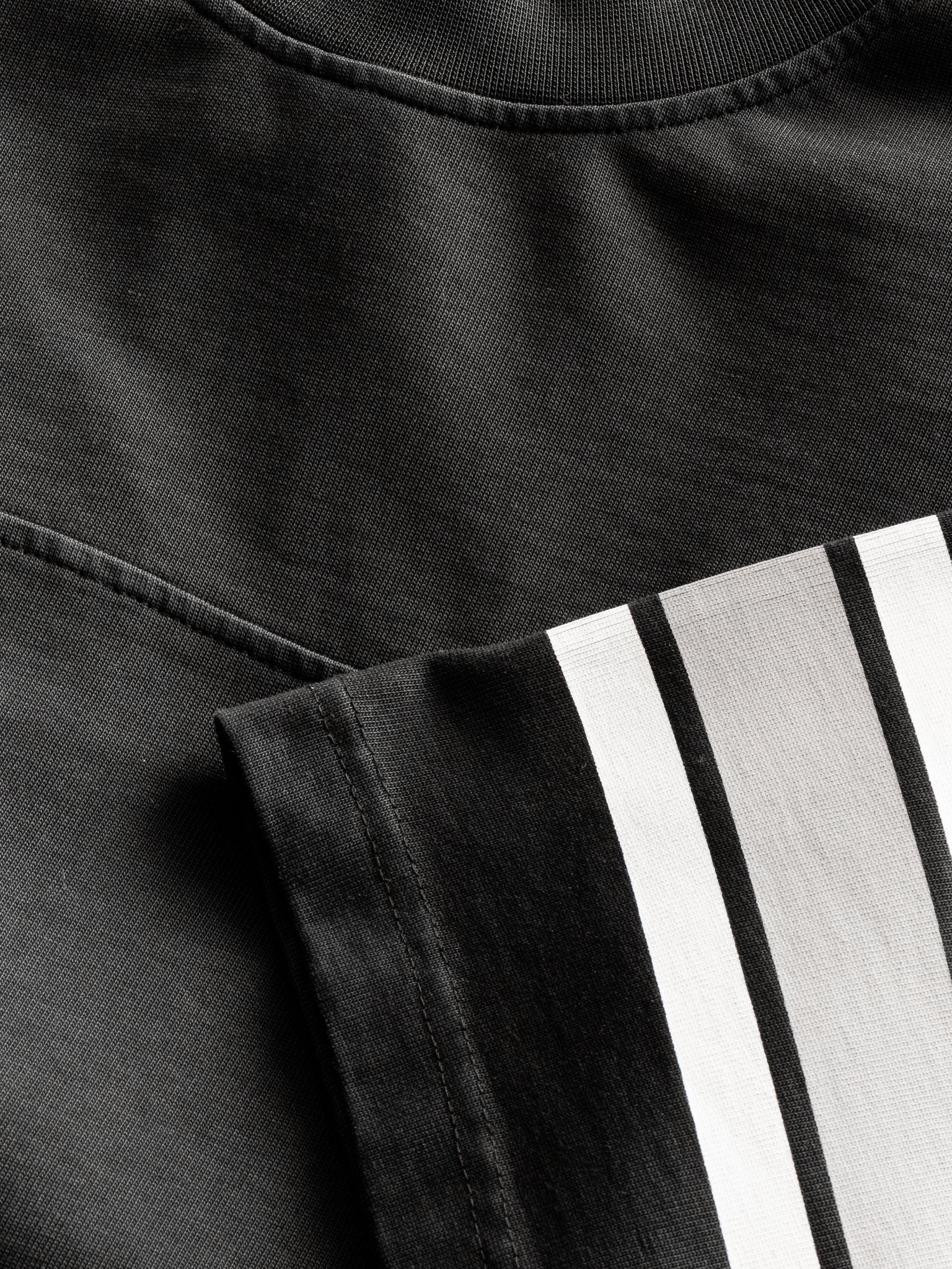 Washed black short-sleeve jersey T-shirt by SWEATS EU laid flat, showing front view with soft fabric texture and simple design.
