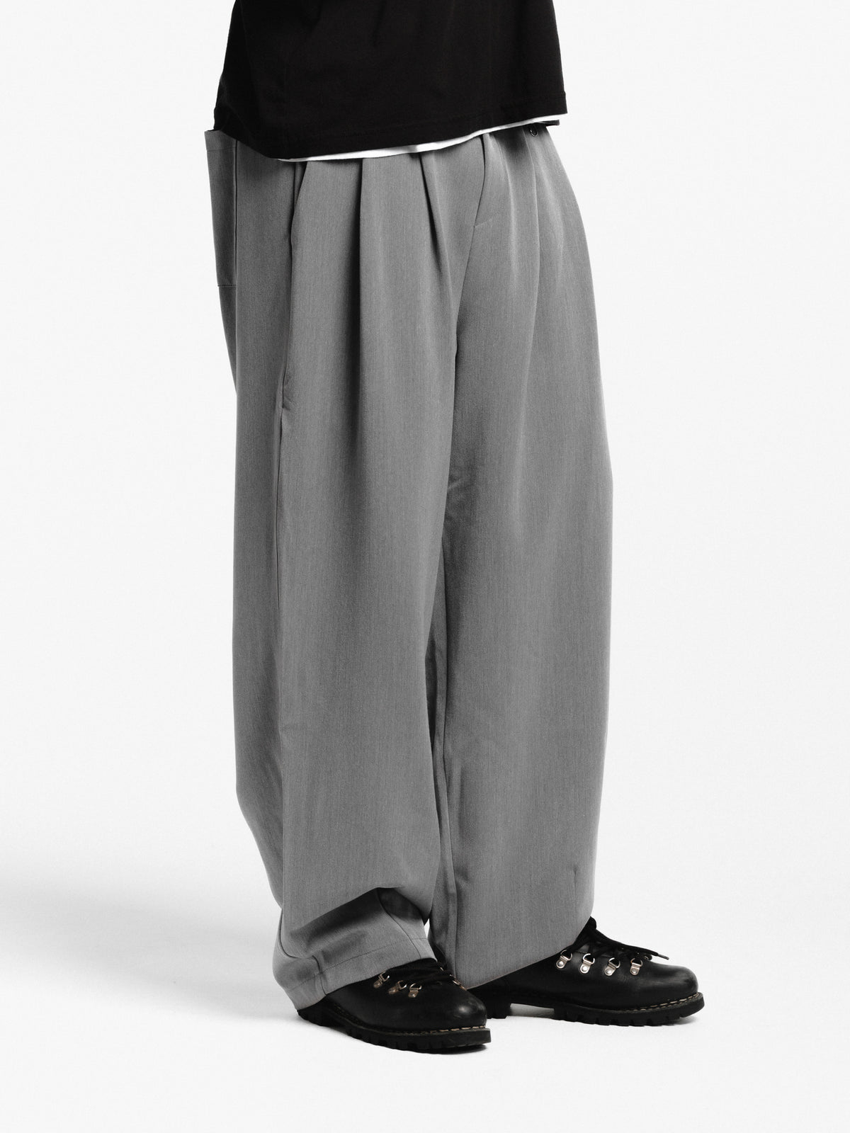 Gray pleated pants by Sweats EU, featuring a tailored fit and classic design, shown on a model.