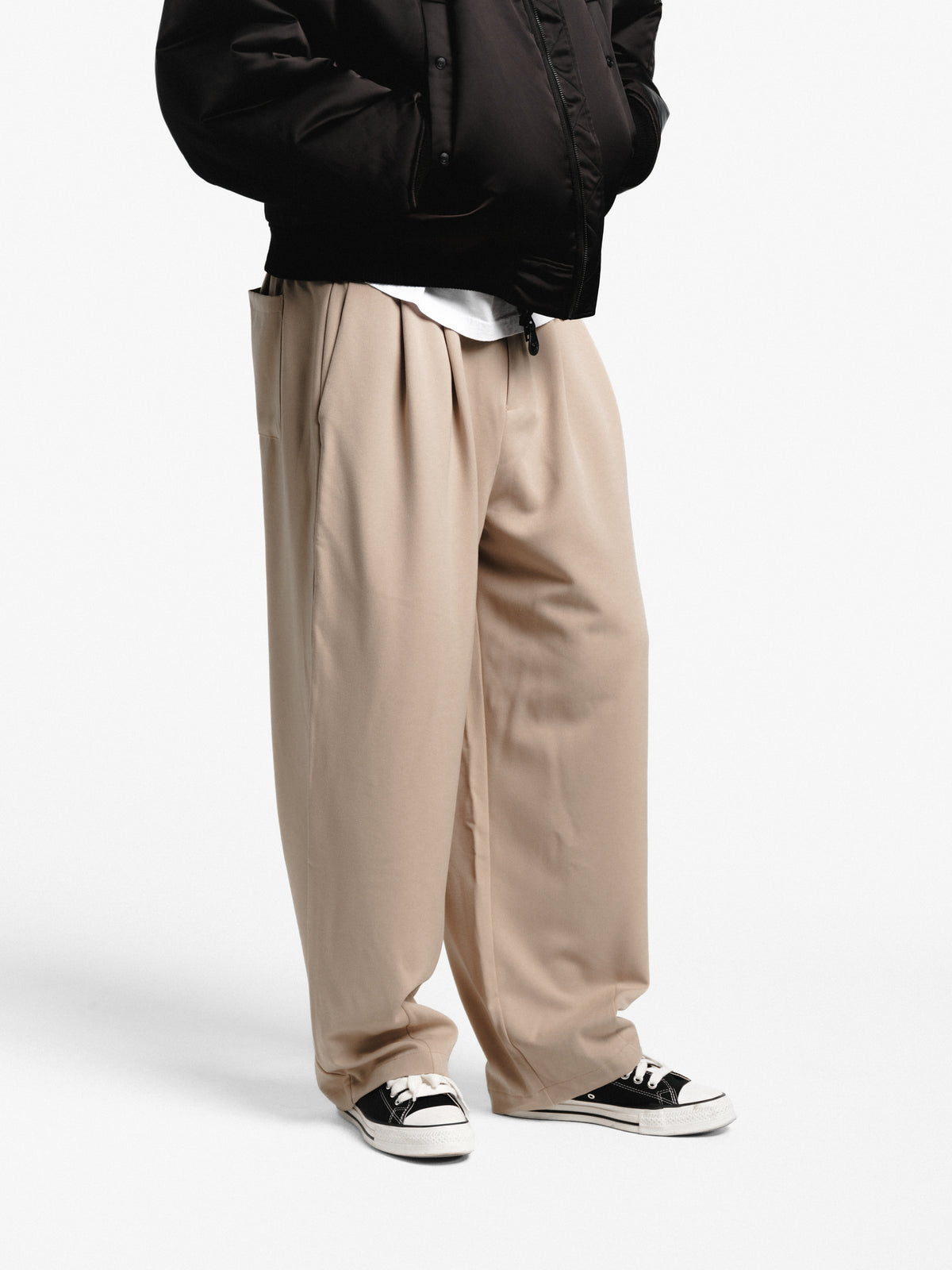 Sand-colored pleated pants from Sweats EU, featuring a tailored fit and stylish pleats on lightweight fabric.