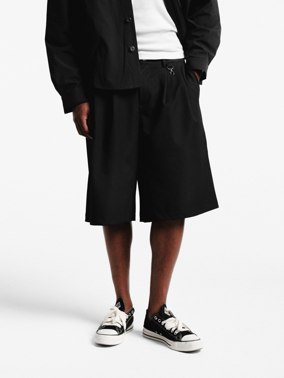 Black pleated shorts by Sweats EU, featuring a stylish pleated design and comfortable fit, shown on a neutral background.
