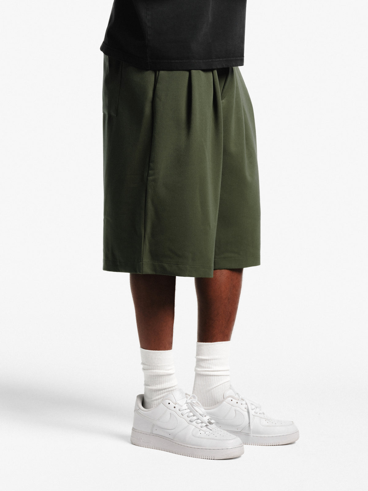 Olive-colored pleated shorts by SWEATS EU featuring a stylish, relaxed fit and lightweight fabric for casual wear.