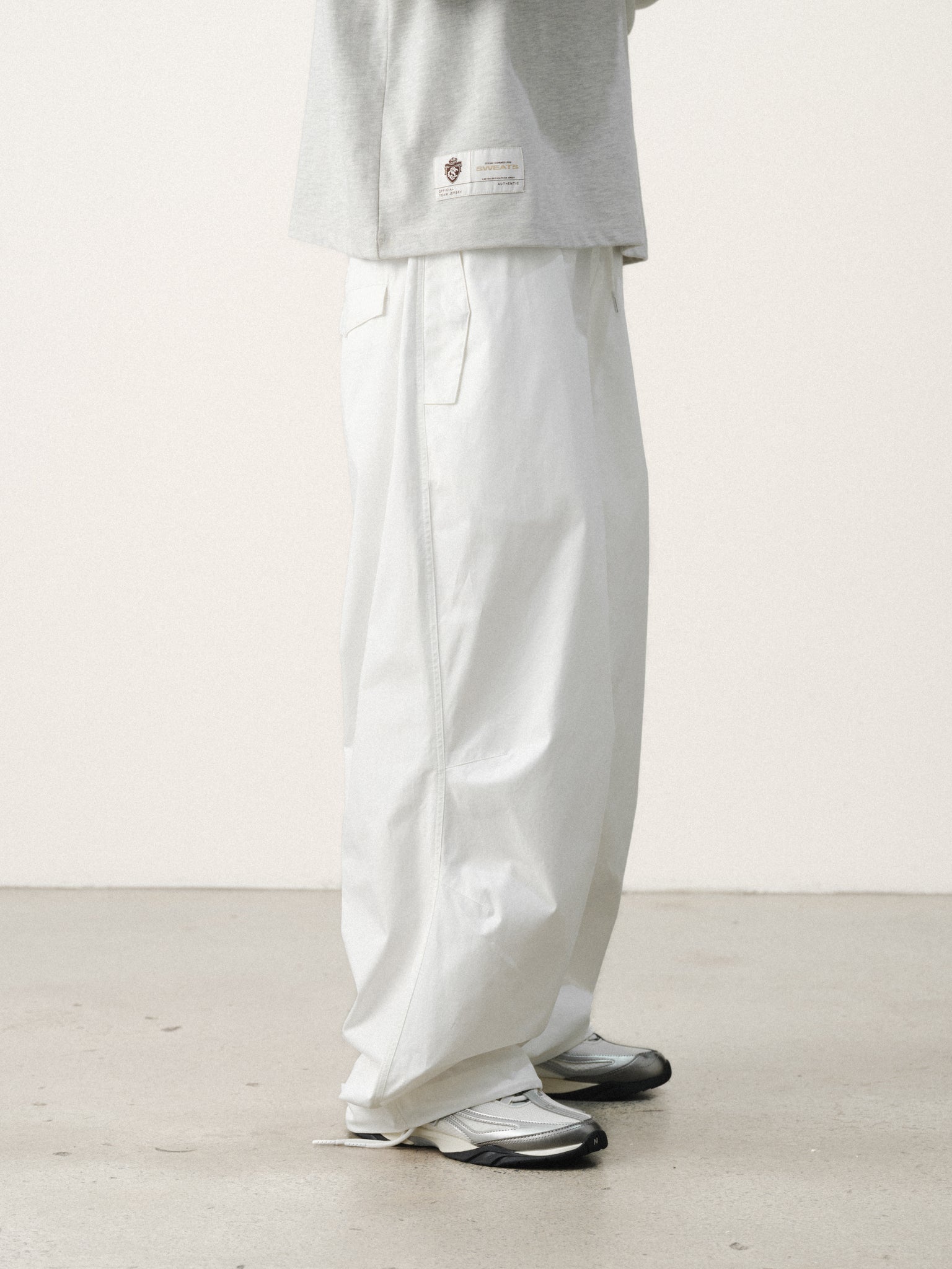 White V3 Flight Pants by SWEATS EU displayed on a model, showcasing their relaxed fit and casual style.