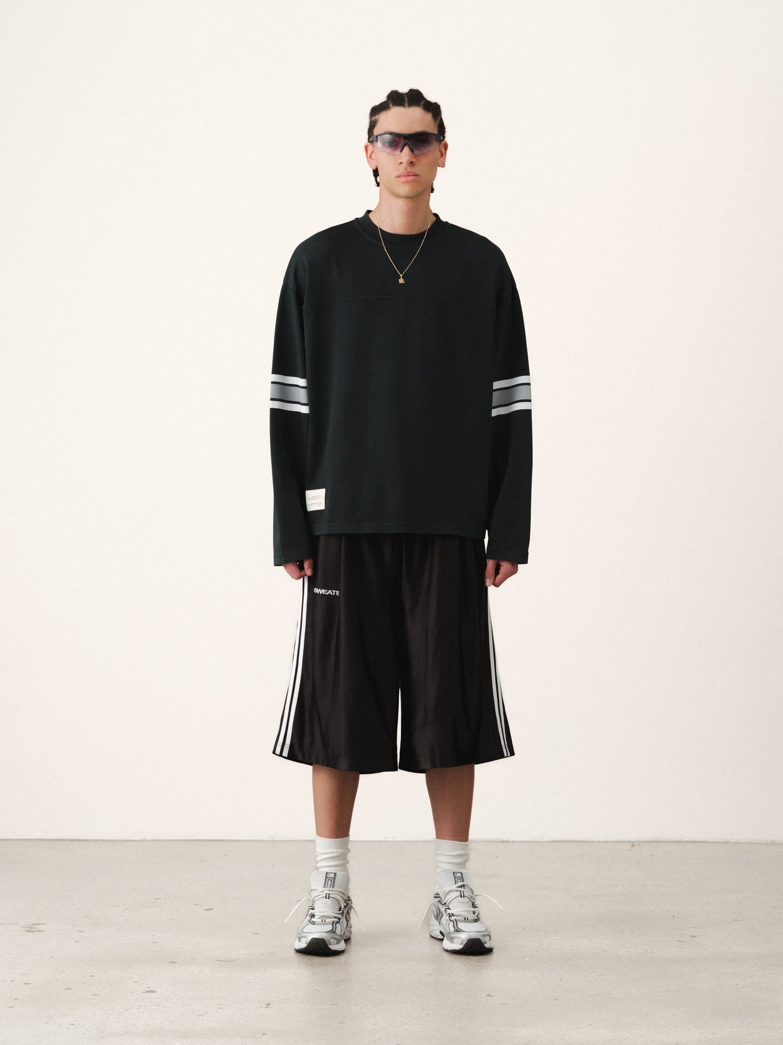 Washed black long-sleeve jersey T-shirt by SWEATS EU displayed on a hanger against a neutral background.