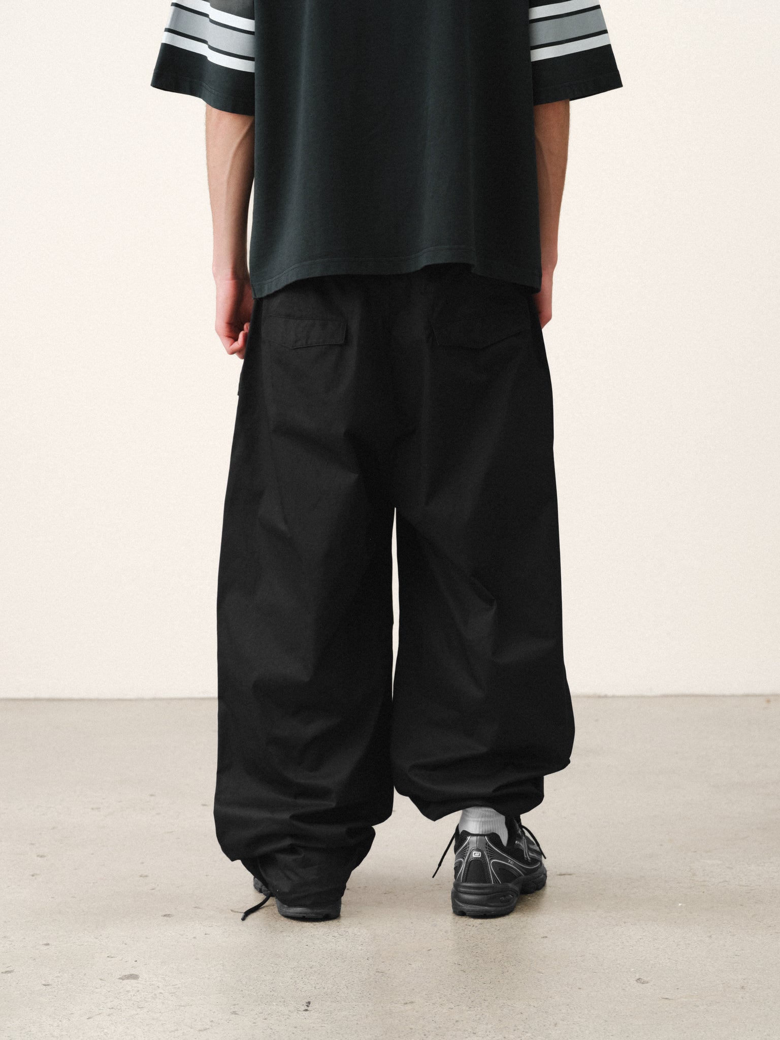 Black V3 Flight Pant by SWEATS EU, featuring a relaxed fit and sporty design, shown on a model in a casual outdoor setting.