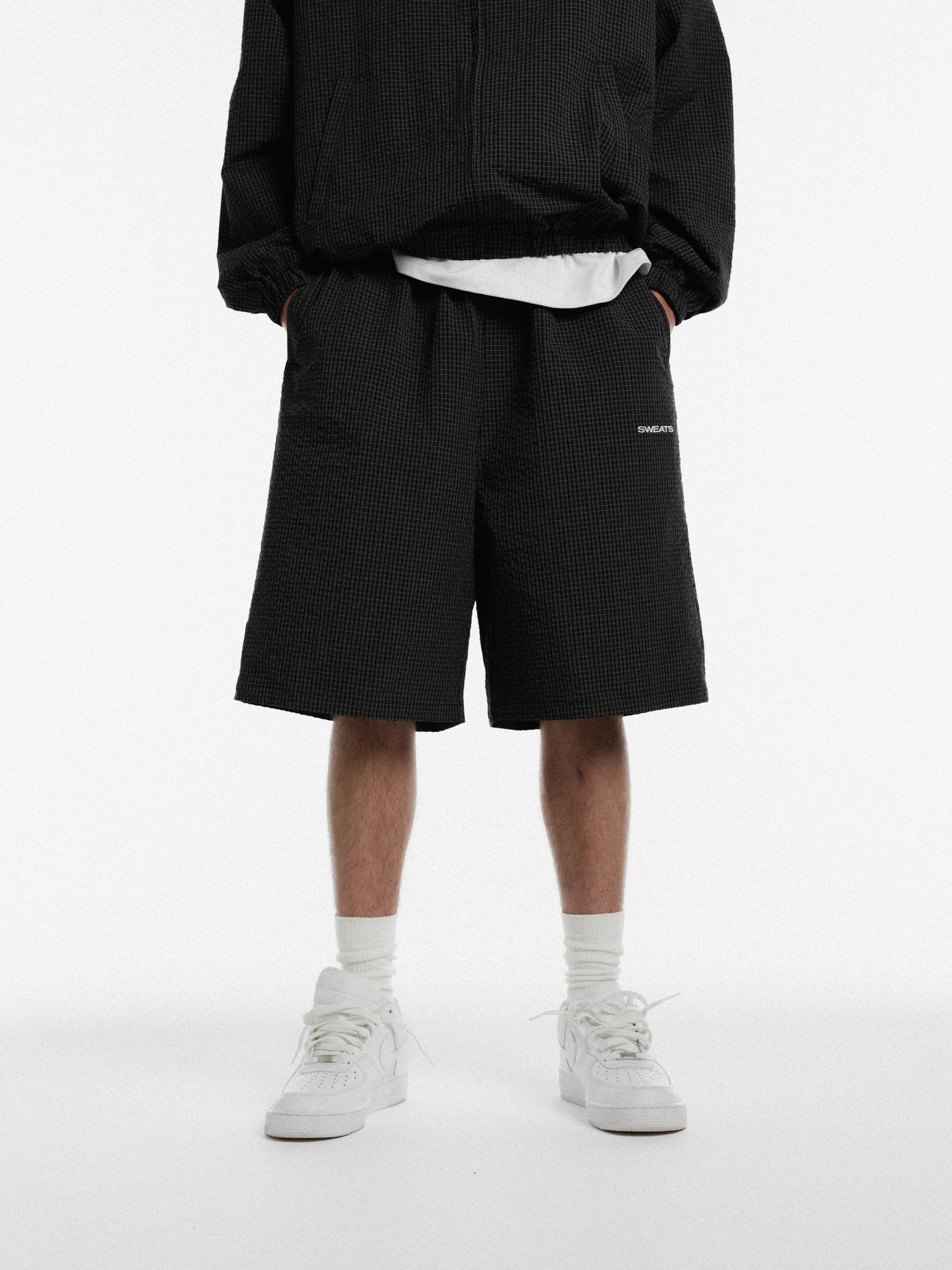 Black and white checked track shorts by SWEATS EU, featuring a comfortable fit and casual sporty design.