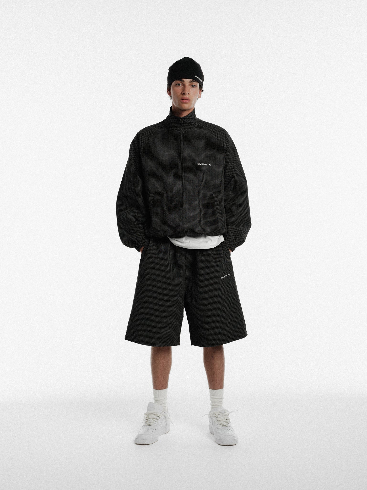 Black and white checkered track shorts by SWEATS EU, featuring a casual sporty design perfect for active wear.