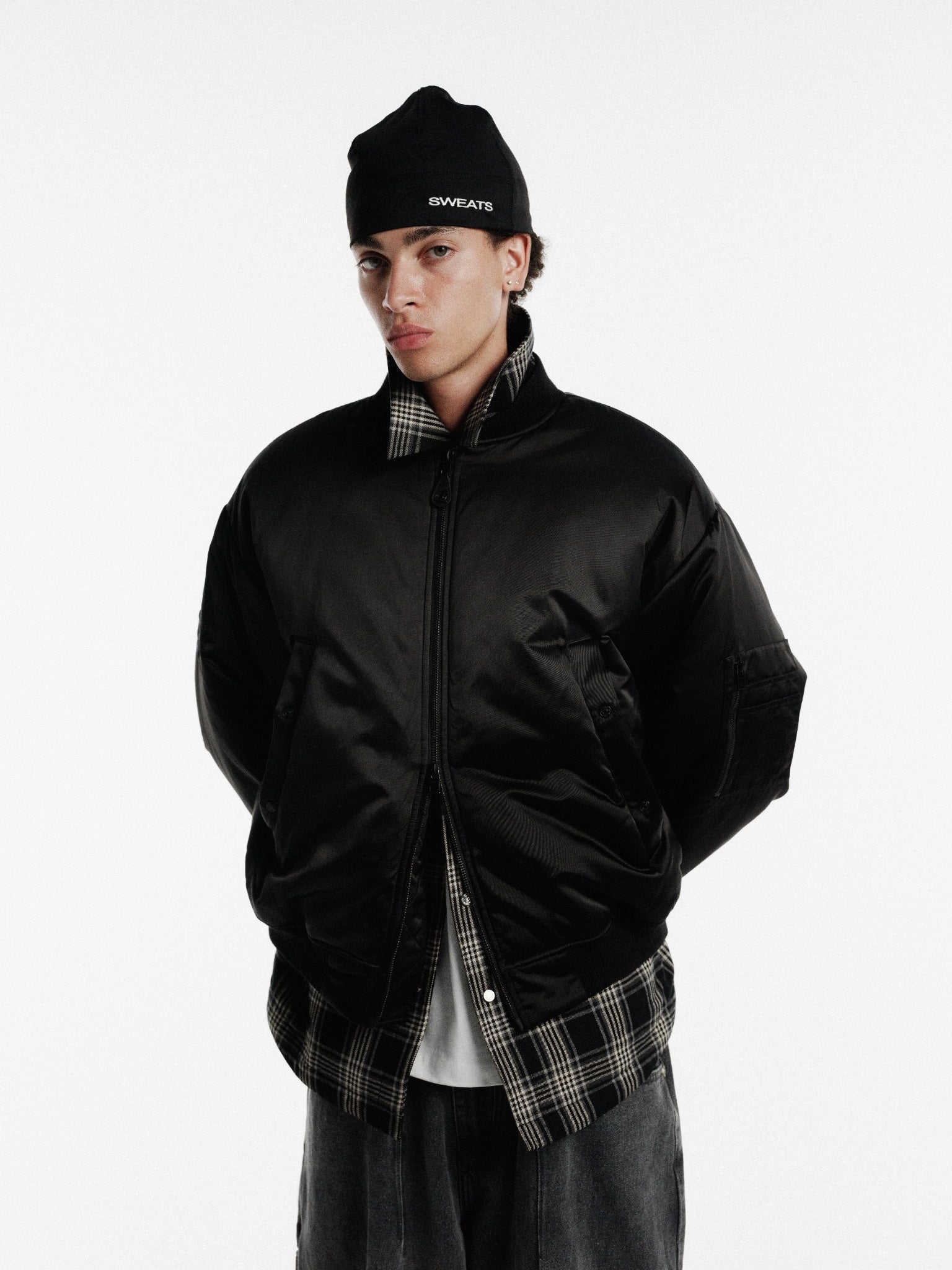 Black bomber jacket by SWEATS EU displayed on a hanger with detailed stitching and a ribbed collar and cuffs.