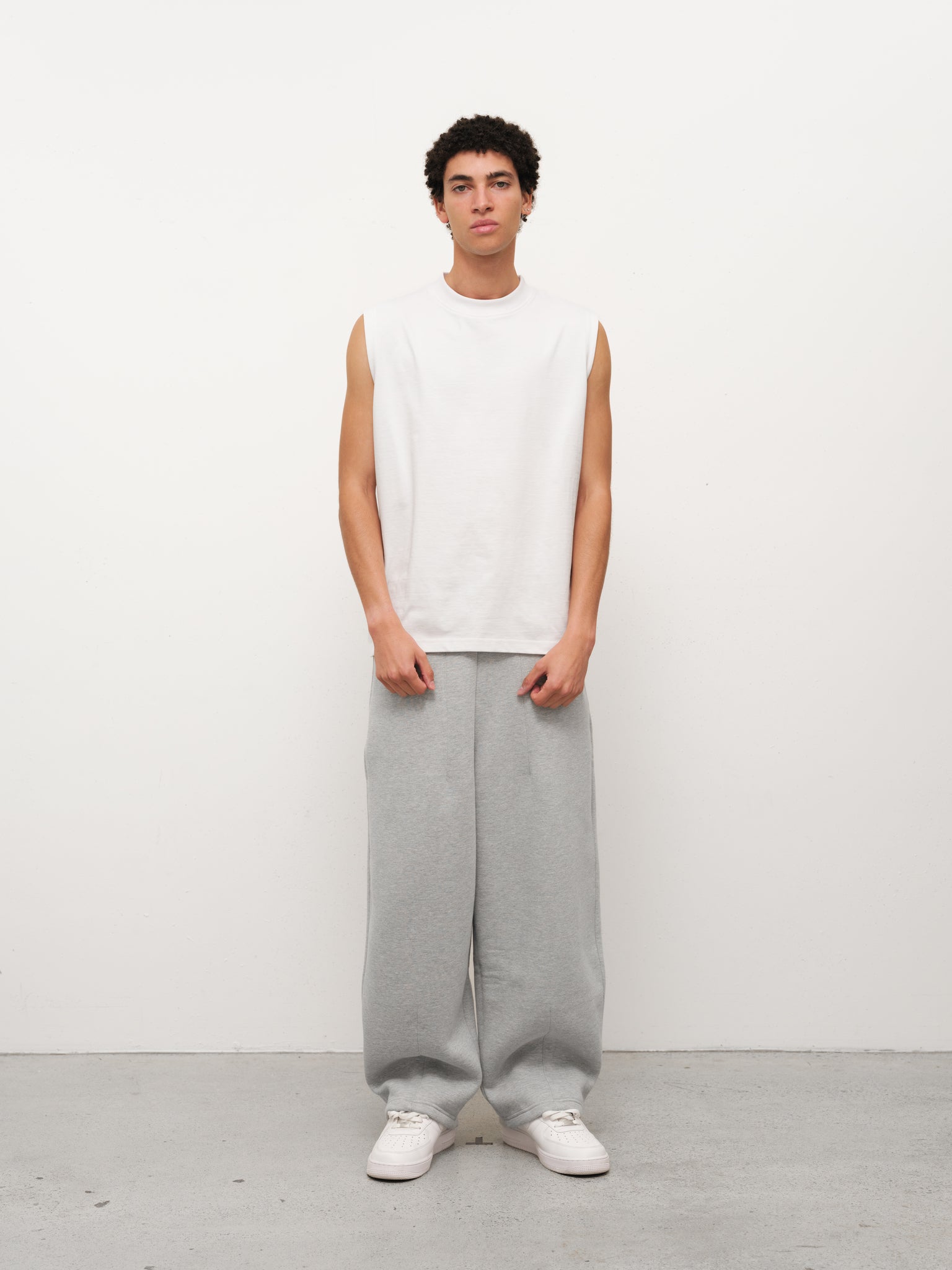 White muscle tee from SWEATS EU, front view showing sleeveless design and fitted cut, ideal for athletic or casual wear.