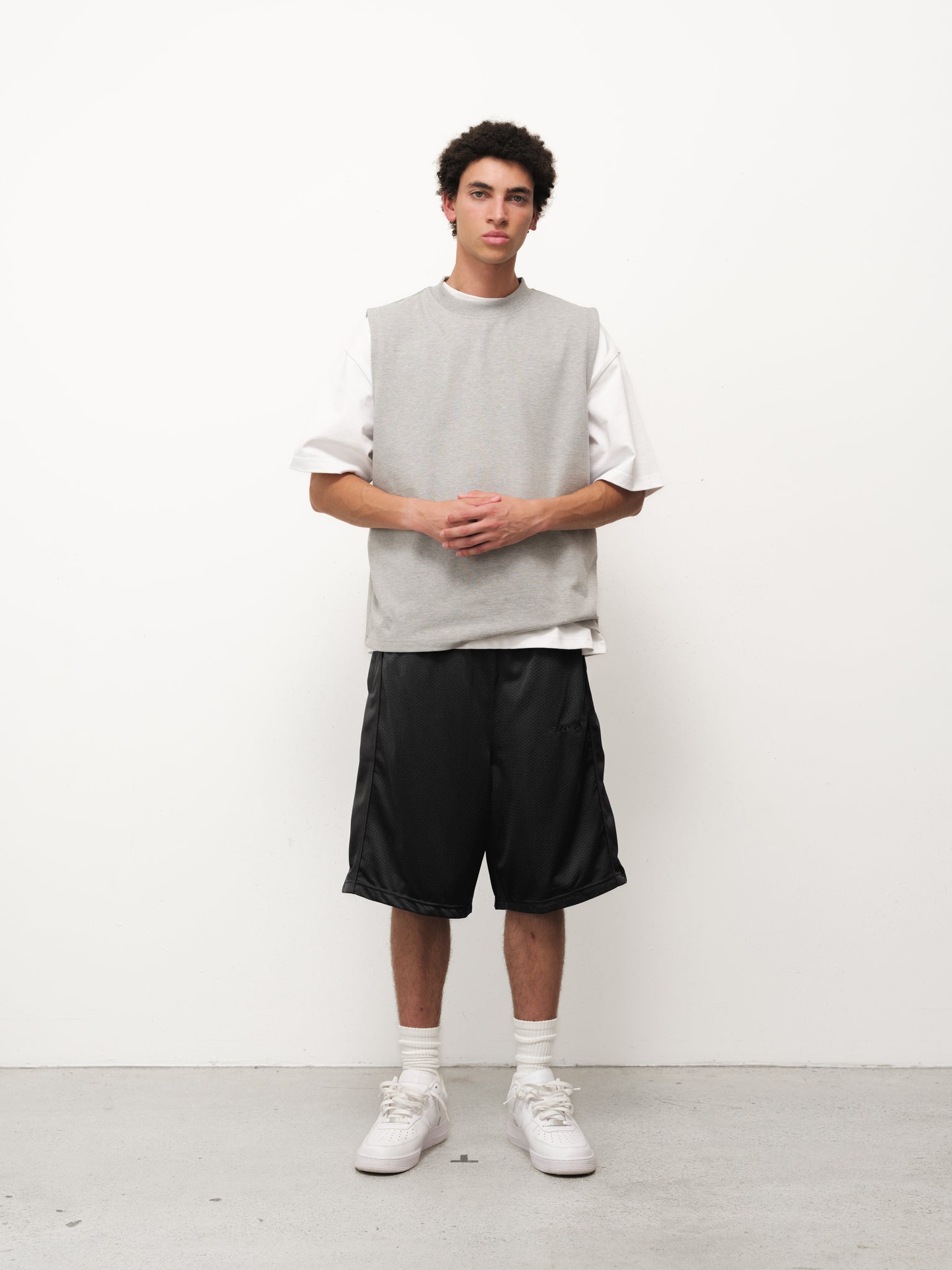 Black mesh shorts from SWEATS EU displayed on a neutral background, showcasing the breathable fabric and relaxed fit.