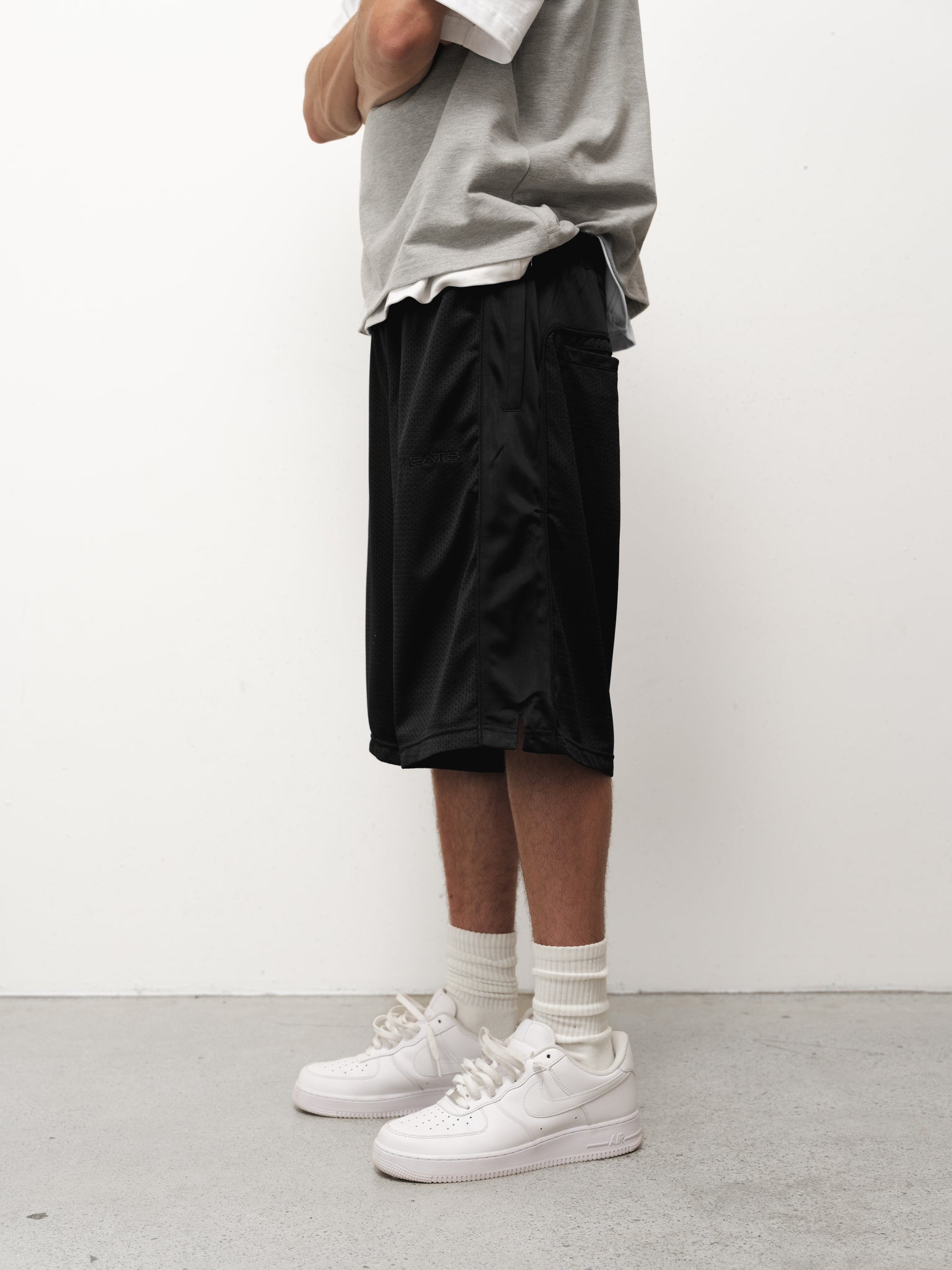 Black mesh shorts by Sweats EU displayed on a flat surface, showcasing the breathable fabric and relaxed fit.