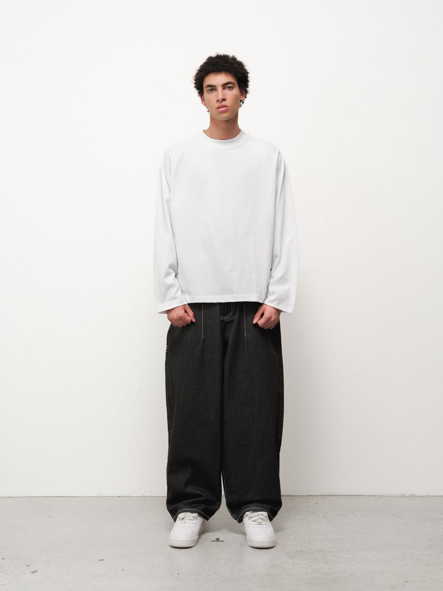 Black denim baggy jeans by Sweats EU, displayed on a model with a relaxed fit and classic five-pocket design.