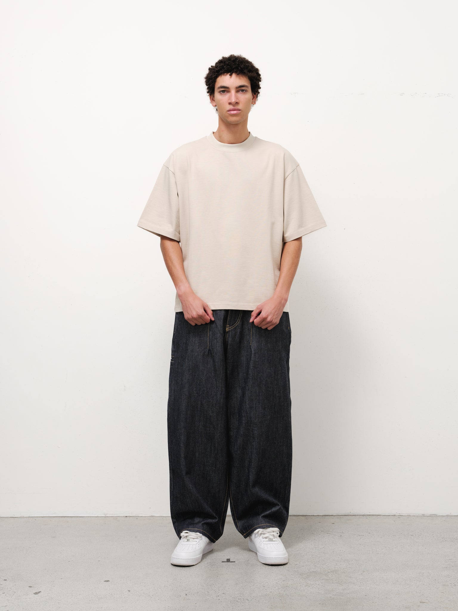 Pair of indigo denim baggy jeans from SWEATS EU, showcasing relaxed fit and classic denim texture, full-length front view.