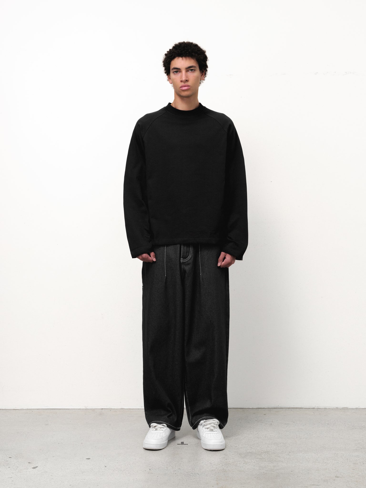 Black long sleeve t-shirt from Sweats EU displayed on a model, showcasing a casual fit and comfortable fabric.