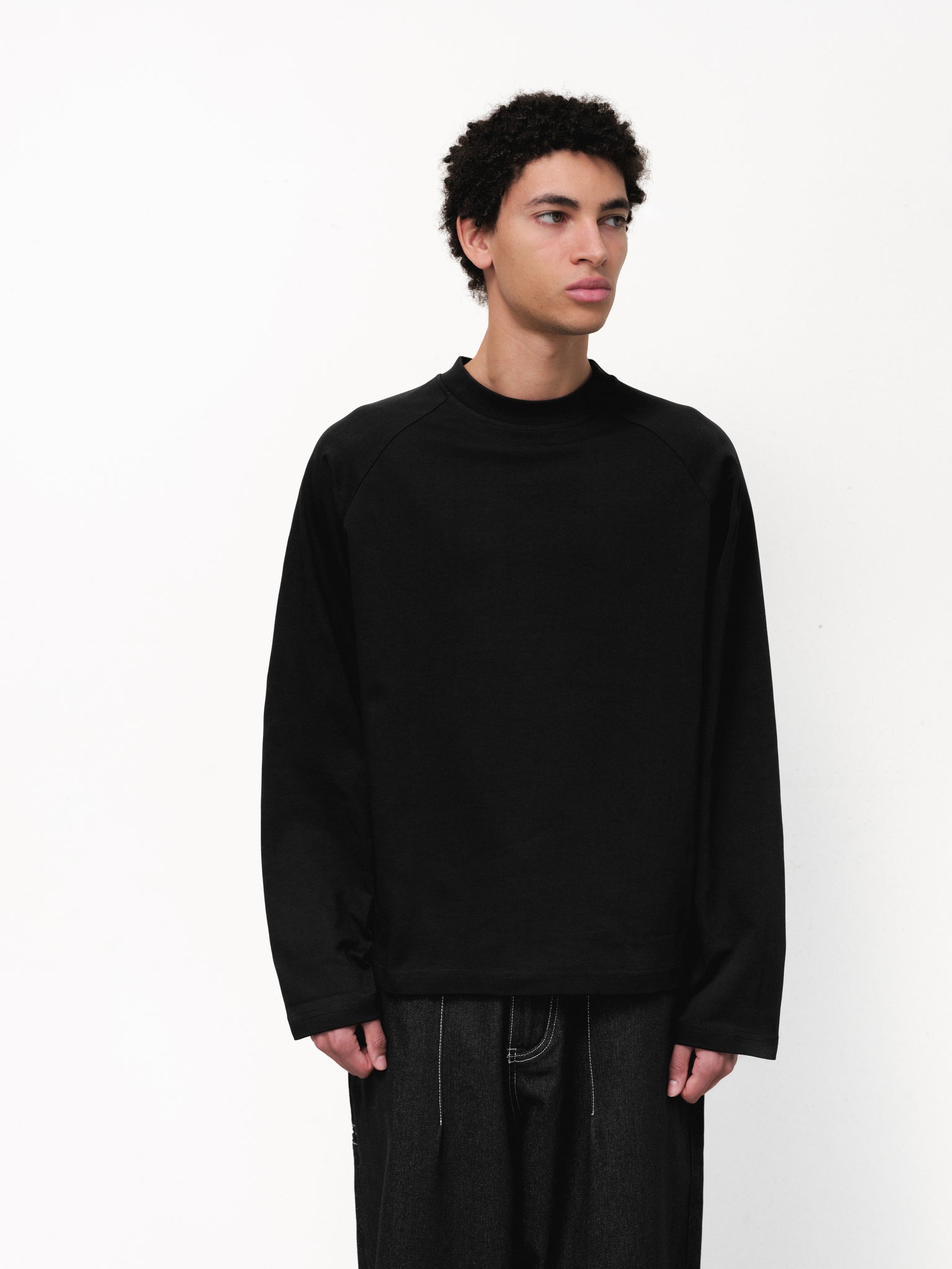 Black long sleeve T-shirt by Sweats EU displayed on a model, showcasing the comfortable fit and simple design.
