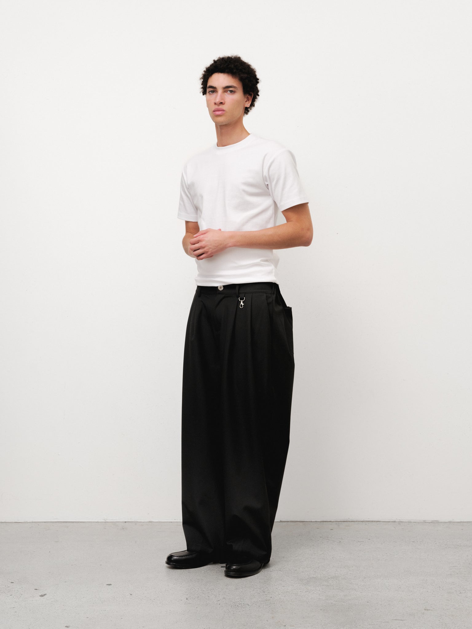 White fitted T-shirt from SWEATS EU, shown on a model with a close-up of the soft, comfortable fabric and classic crew neckline.