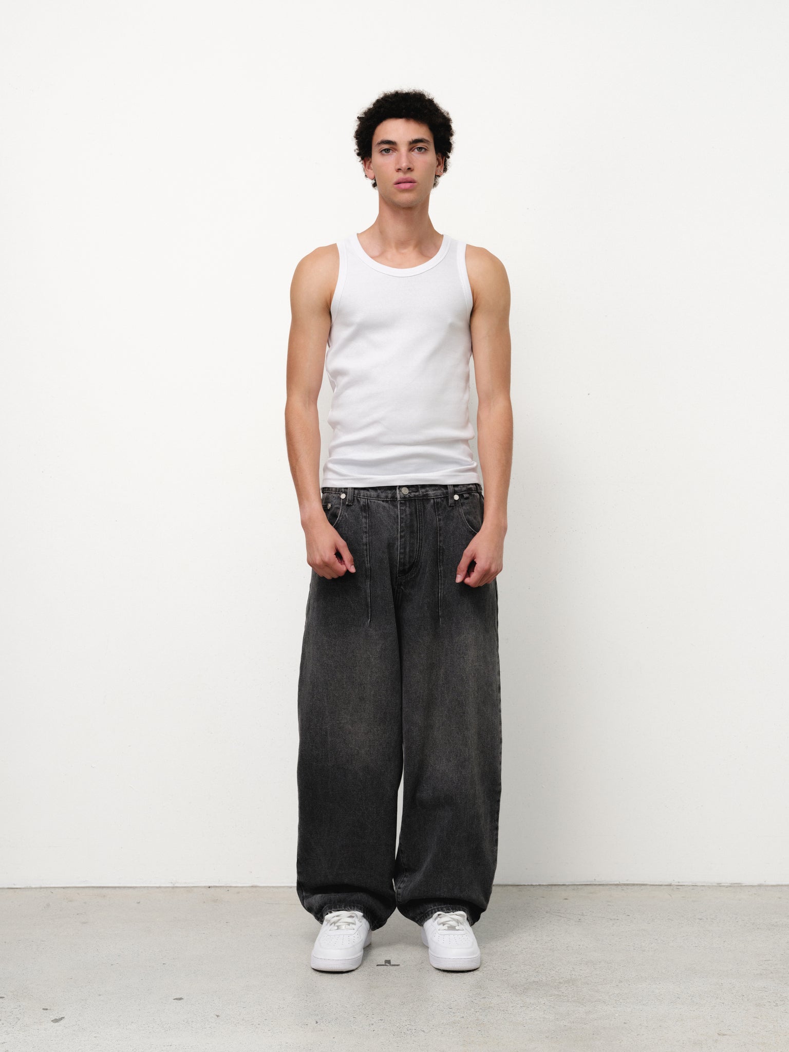 White tank singlet by Sweats EU displayed on a model, showcasing a casual sleeveless top perfect for warm weather.
