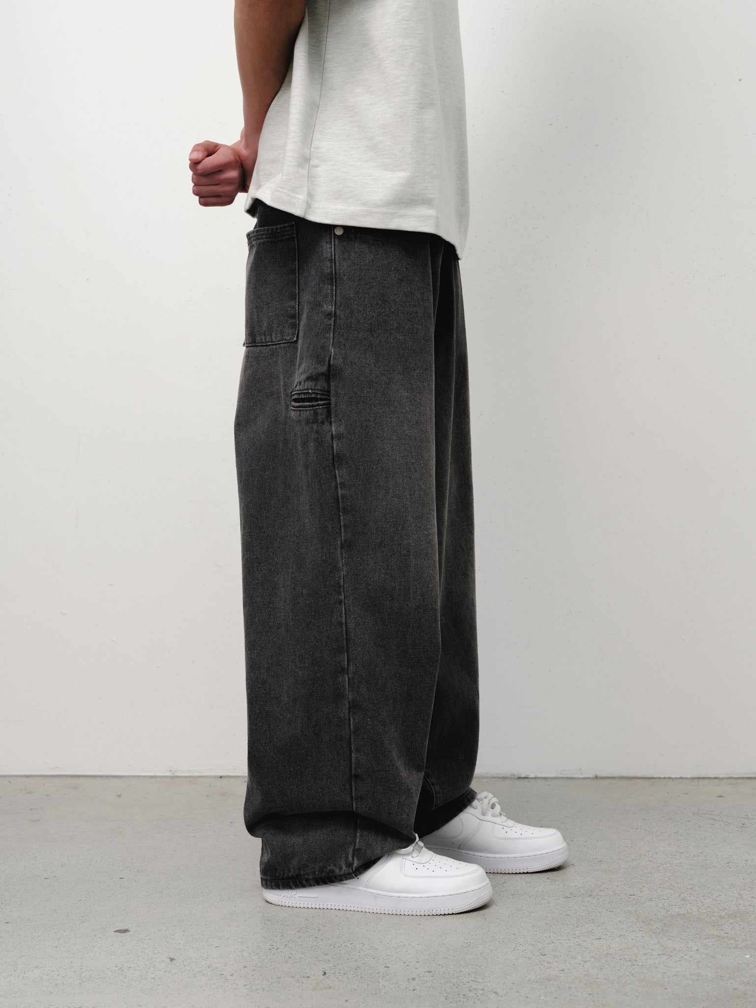 Washed black denim baggy jeans by SWEATS EU displayed on a model, showcasing relaxed fit and casual style.
